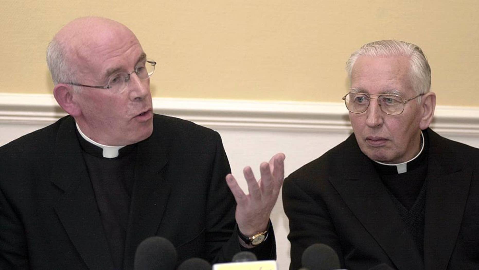 FILE - In this Monday, April 8, 2002 file photo, Archbishop of Armagh Sean Brady, left, makes a point as Cardinal Desmond Connell looks on, during a press conference after the meeting of Ireland's Catholic bishops at St Patrick's College, Maynooth County Meath, Ireland. Catholic Cardinal Desmond Connell, whose tenure as Dublin archbishop was dominated by revelations of pedophilia in the priesthood, has died at the age of 90. The Dublin Archdiocese said Connell died Tuesday, Feb. 21, 2017 in his sleep after a long illness. He oversaw the archdiocese from 1988 to 2004 and was elevated to cardinal in 2001. (AP Photo/John Cogill, file)