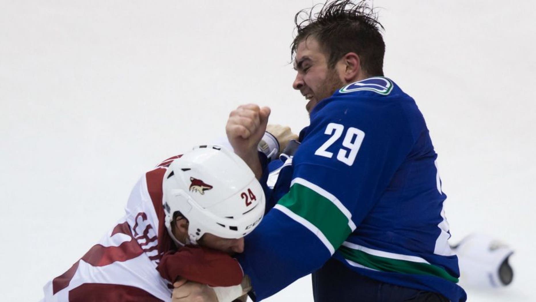 Vancouver Canucks' Tom Sestito, right, and Arizona Coyotes' Kyle Chipchura fight during the second period of an NHL hockey game in Vancouver, British Columbia, Monday, Dec. 22, 2014. (AP Photo/The Canadian Press, Darryl Dyck)