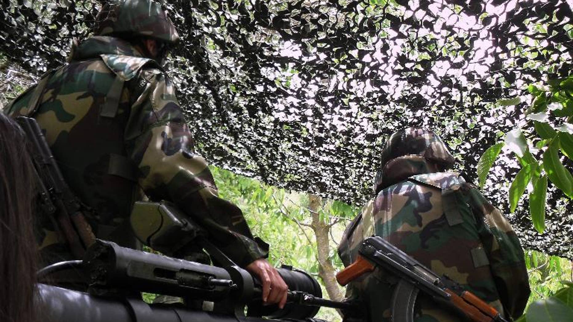 Lebanese Hezbollah militants stand in their post in Iqlim al-Touffah, southern Lebanon on May 16, 2010