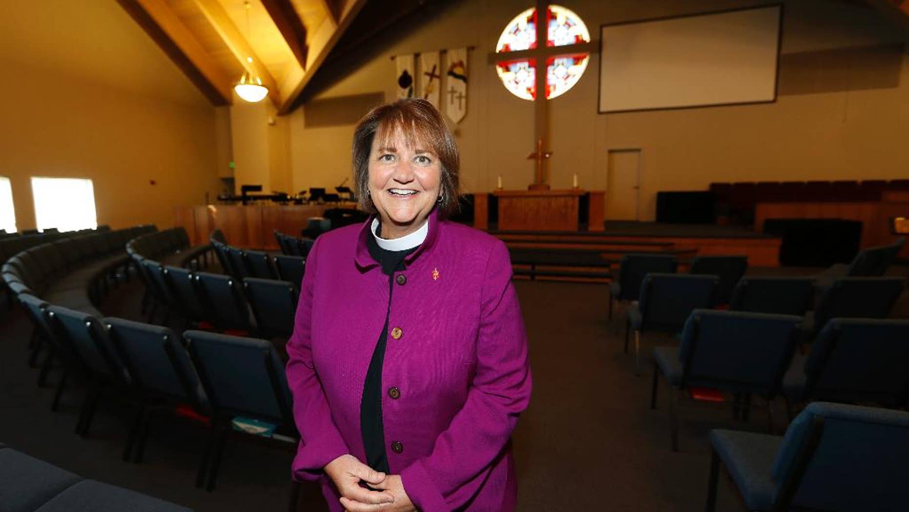 In this Wednesday, April 19, 2017, photo, Bishop Karen Oliveto poses for a photo in the sanctuary of a United Methodist Church in Highlands Ranch, Colo. The top court in the United Methodist Church on Tuesday, April 25, will consider whether the election of Oliveto, the first openly lesbian Methodist bishop, violated church law barring clergy who are ``self-avowed practicing homosexuals.’’ (AP Photo/David Zalubowski)