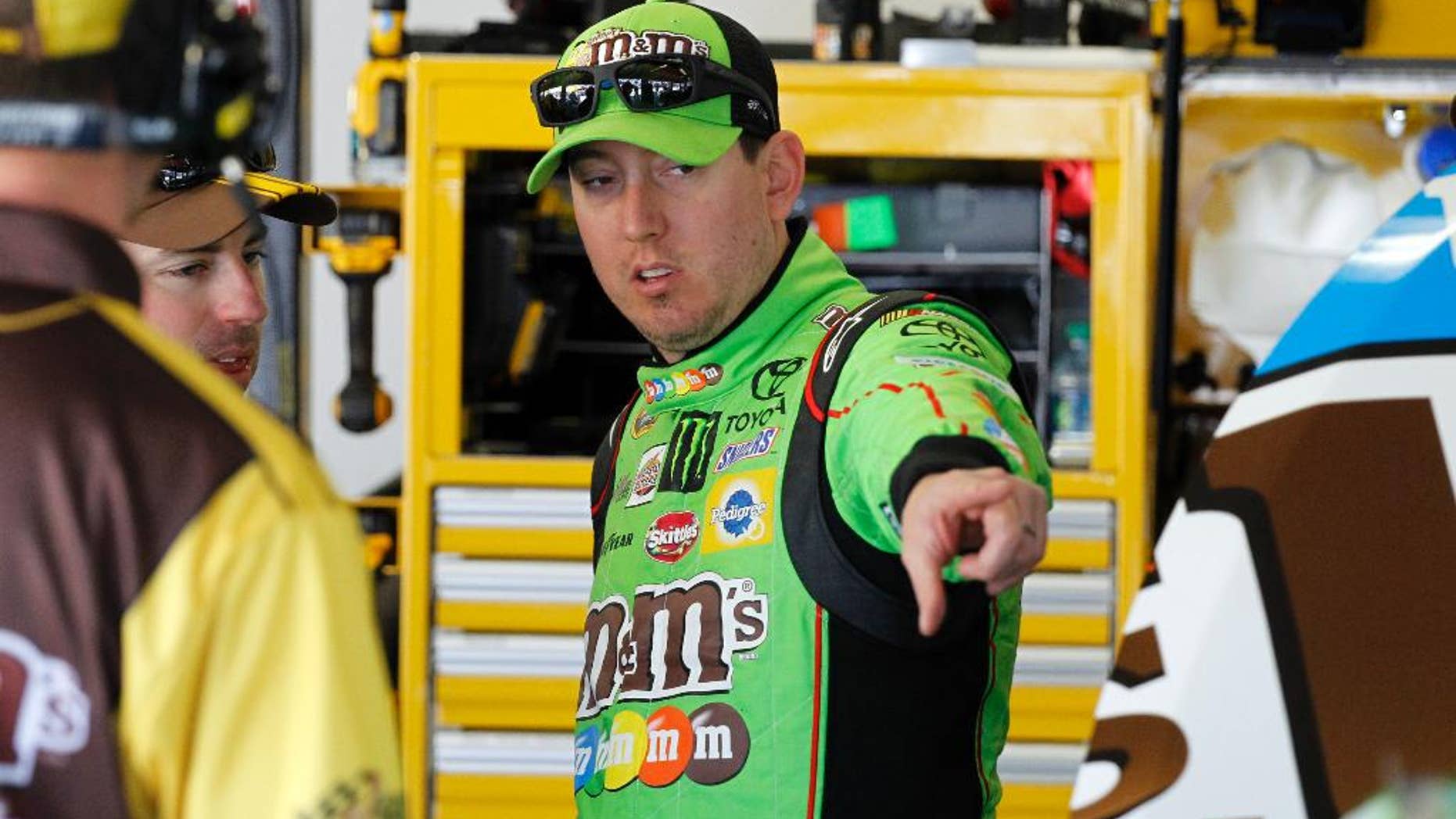 Kyle Busch talks to crew members during practice for the Daytona 500 NASCAR Sprint Cup series auto race at Daytona International Speedway in Daytona Beach, Fla., Friday, Feb. 20, 2015. (AP Photo/Terry Renna)