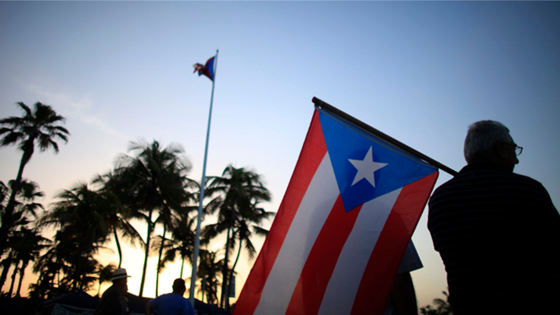 People gather in front of the Puerto Ricos Capitol building to protest against Gov. Alejandro Garcia Padilla's budget proposal for the next fiscal year in San Juan, Thursday, April 30, 2015. Legislators struck down a key part of a plan to overhaul the island's tax system early Thursday, raising concerns about the U.S. territory's economic future and its ability to pay off a heavy public debt. (AP Photo/Ricardo Arduengo)