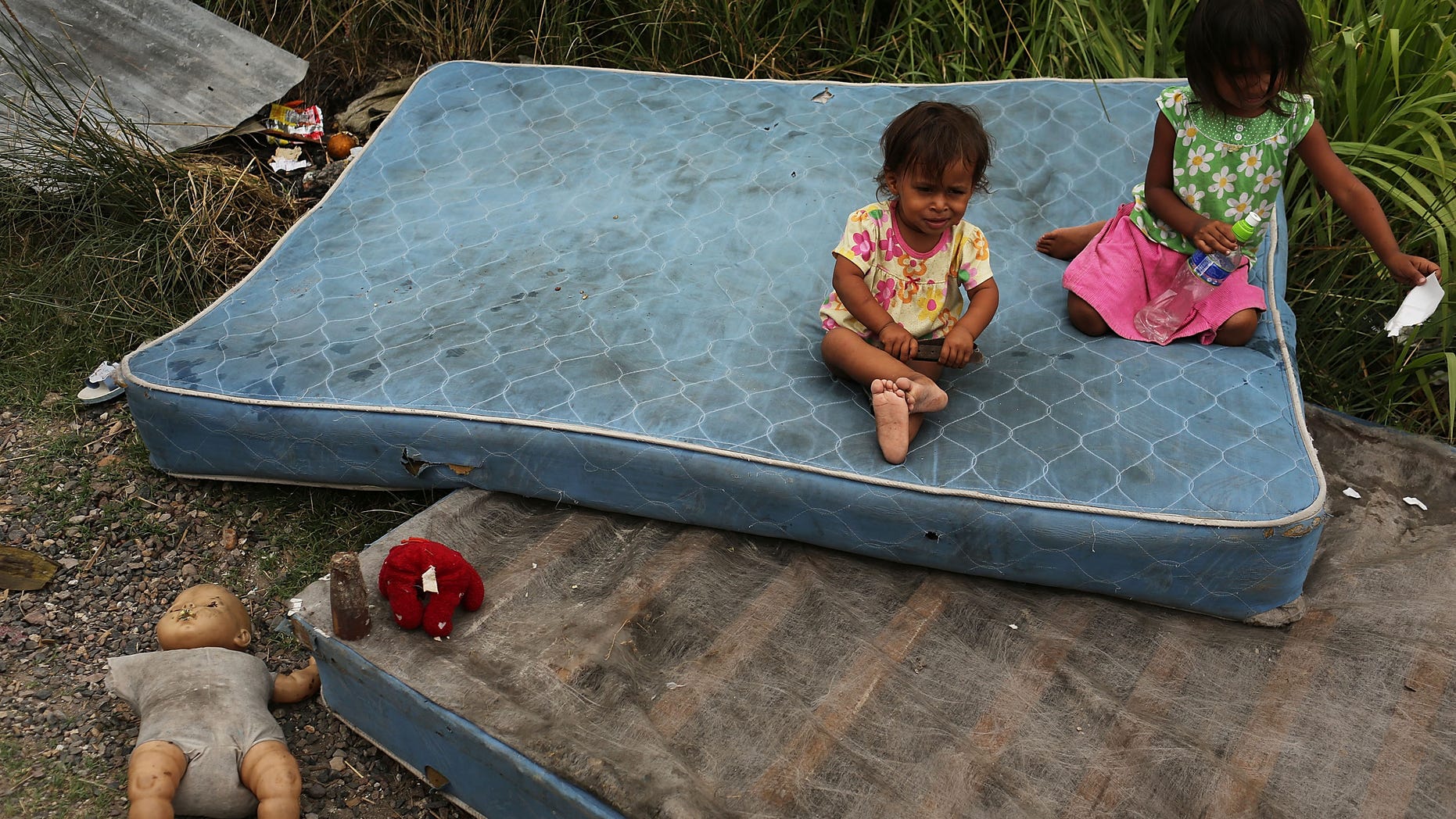 TEGUCIGALPA, HONDURAS - JULY 20: Children sit on mattresses as their home and neighborhood are forcefully dismantled in a shanty town after the government claimed that the settlement was illegal on July 20, 2012 in Tegucigalpa, Honduras. Land disputes are becoming increasingly frequent in Honduras which is alarming the nation's business class while sowing fears of increased political violence. In a nation where 72% of the poorest landowners hold only 11.6% of cultivated land, tensions are rising as the poor have few places to go and little opportunities for productive employment. Honduras now has the highest per capita murder rate in the world and its capital city, Tegucigalpa, is plagued by violence, poverty, homelessness and sexual assaults. With an estimated 80% of the cocaine entering the United States now being trans-shipped through Honduras, the violence on the streets is a spillover from the ramped rise in narco-trafficking. (Photo by Spencer Platt/Getty Images)