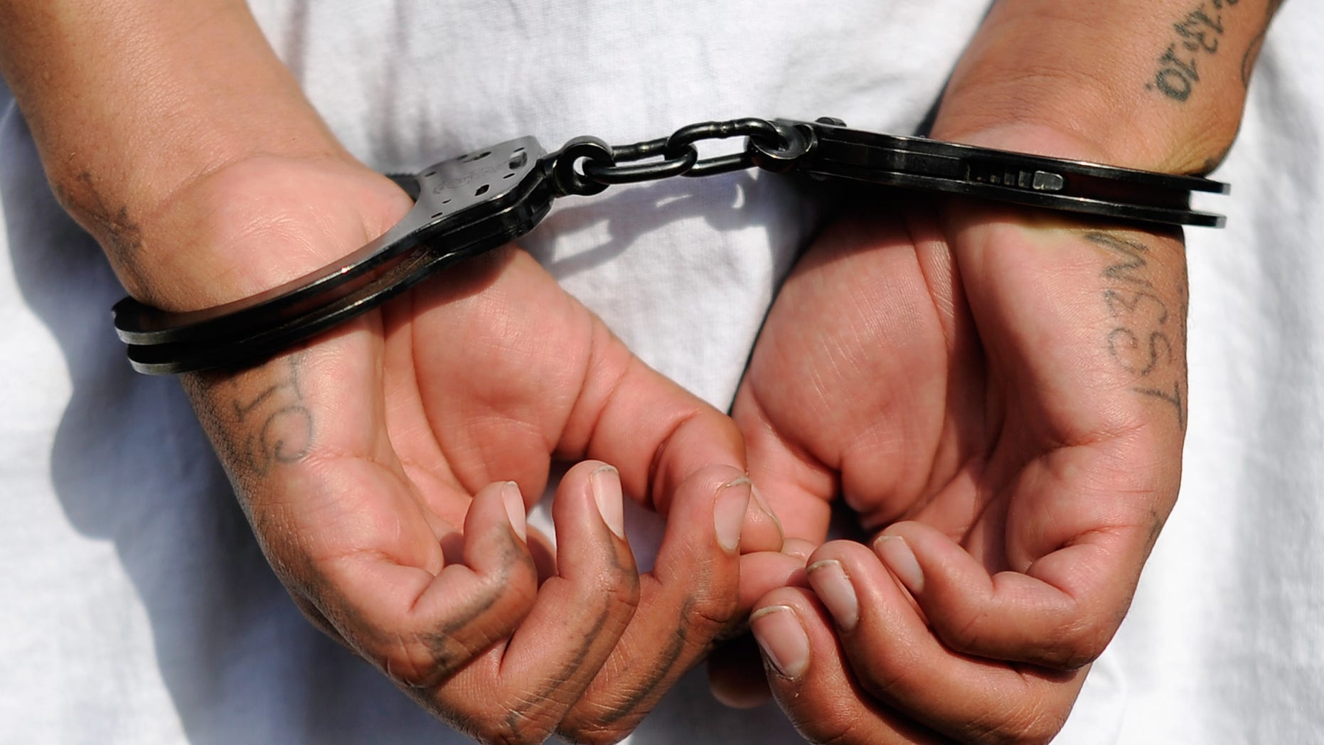LOS ANGELES, CA - APRIL 29: Handcuffs are seen on the hands of a twenty-year old "Street Villains" gang member who was arrested by Los Angeles Police Department officers from the 77th Street division on April 29, 2012 in Los Angeles, California. The 77th Street division patrol the same neighborhood that truck driver Reginald Denny was nearly beaten to death by a group of black assailants at the intersection of Florence and Normandie Avenues. It?s been 20 years since the verdict was handed down in the Rodney King case that sparked infamous Los Angeles riots. (Photo by Kevork Djansezian/Getty Images)