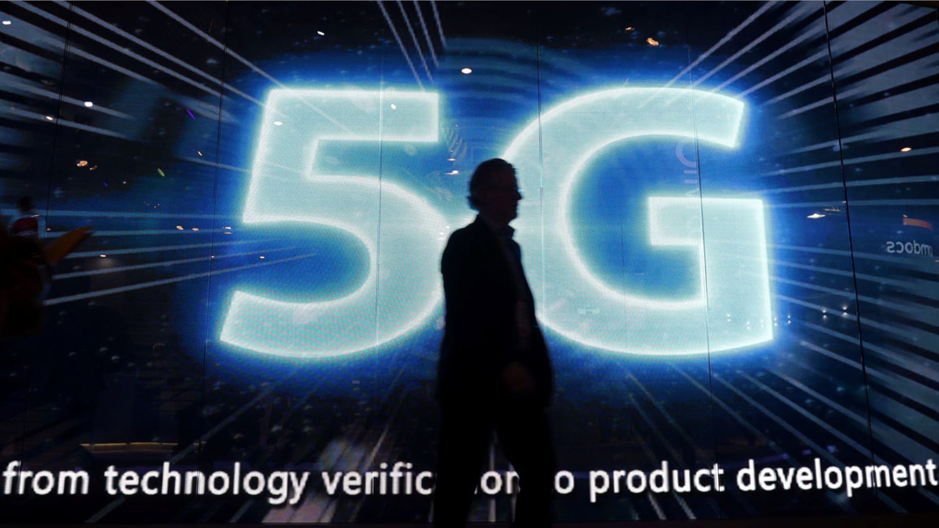 FILE: A visitors walks past a 5G sign during Mobile World Congress in Barcelona last year. The technology is seen as a "key area of competition" internationally.