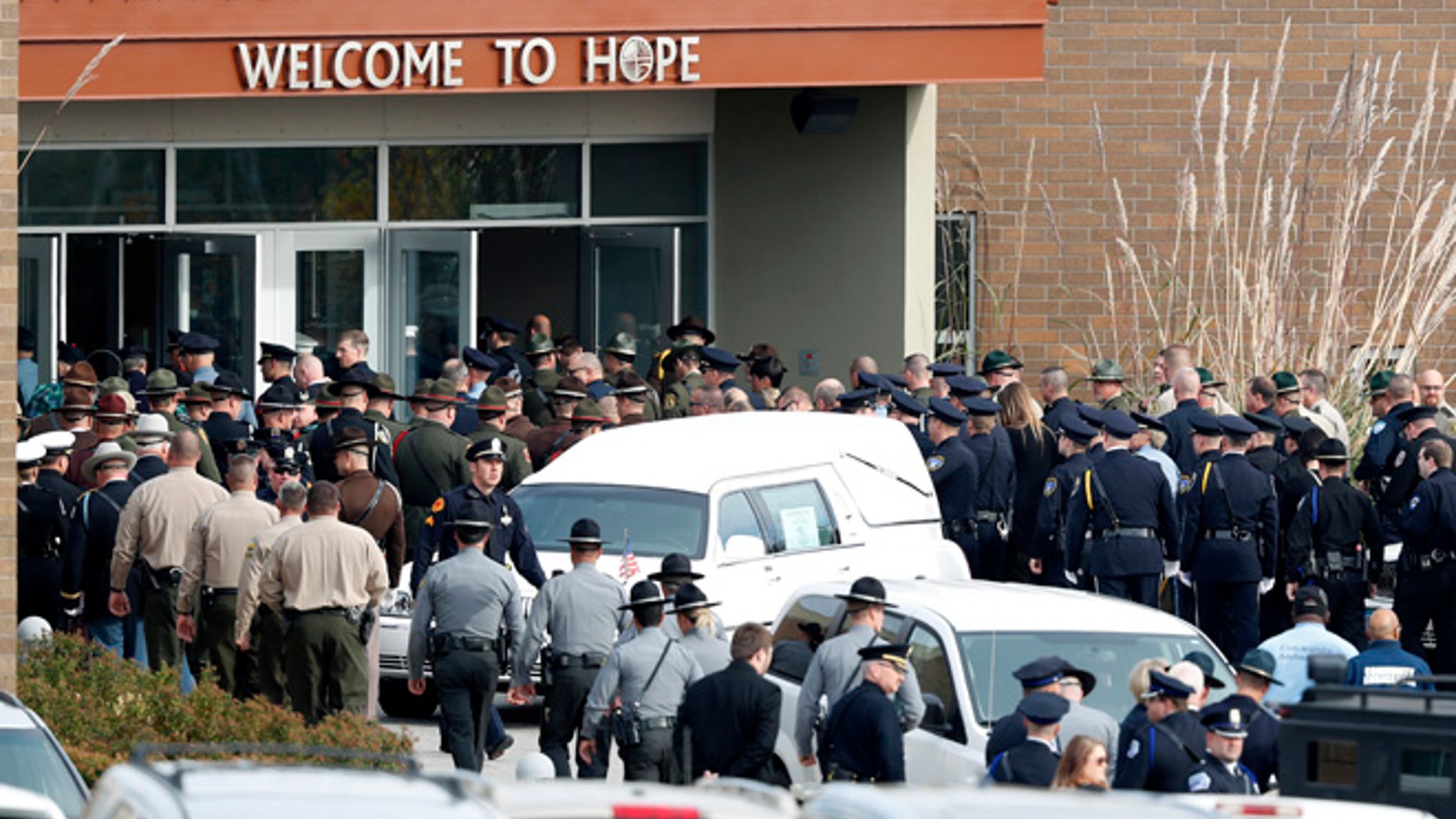 Law enforcement officers enter the Lutheran Church of Hope before funeral services for Des Moines police officer Sgt. Anthony Beminio