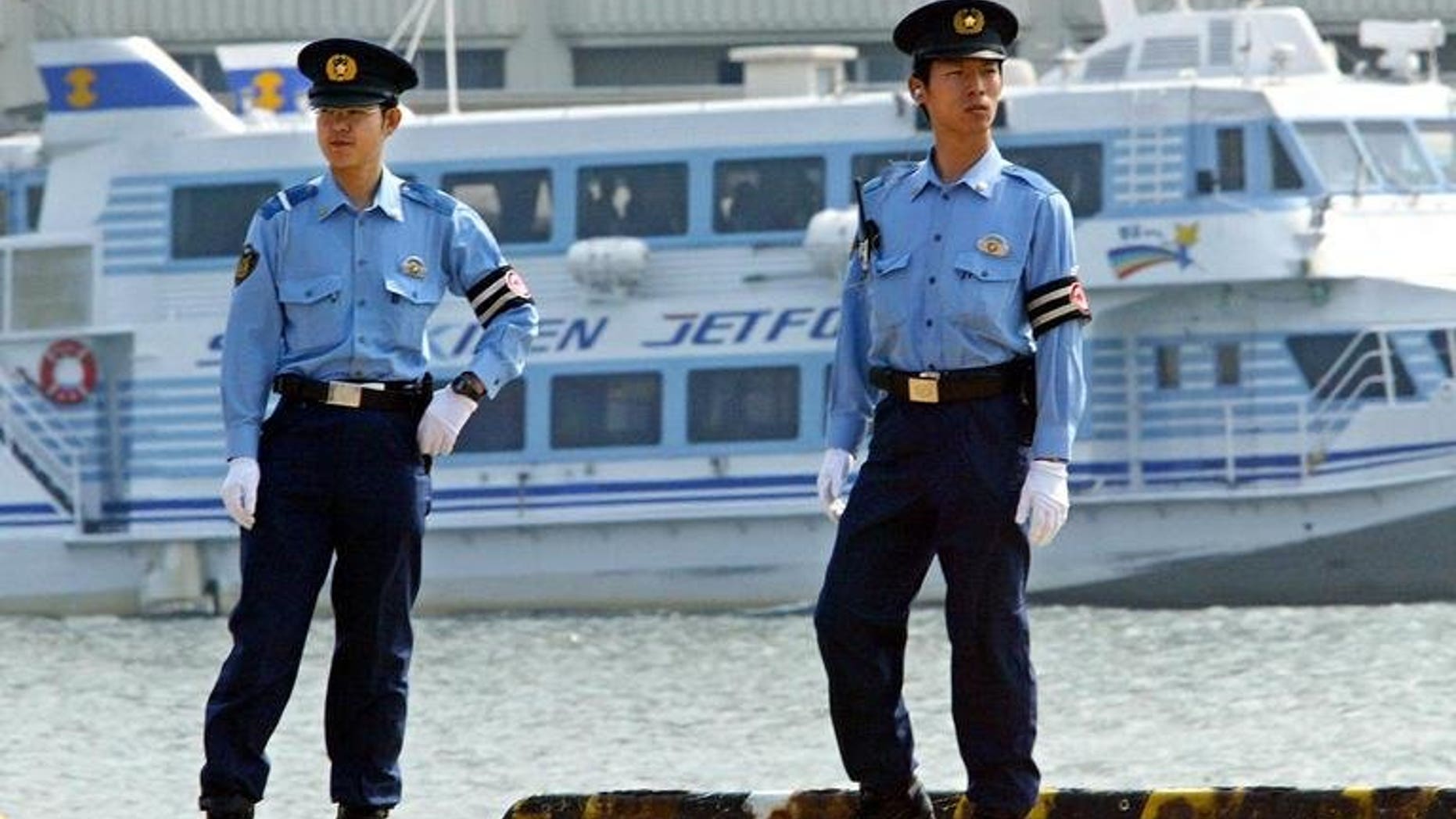 Japanese policemen patrol the Niigata Port, on June 8, 2003. Japanese police are hunting for a "haiku poet"suspected of killing five people in a tiny mountain village.