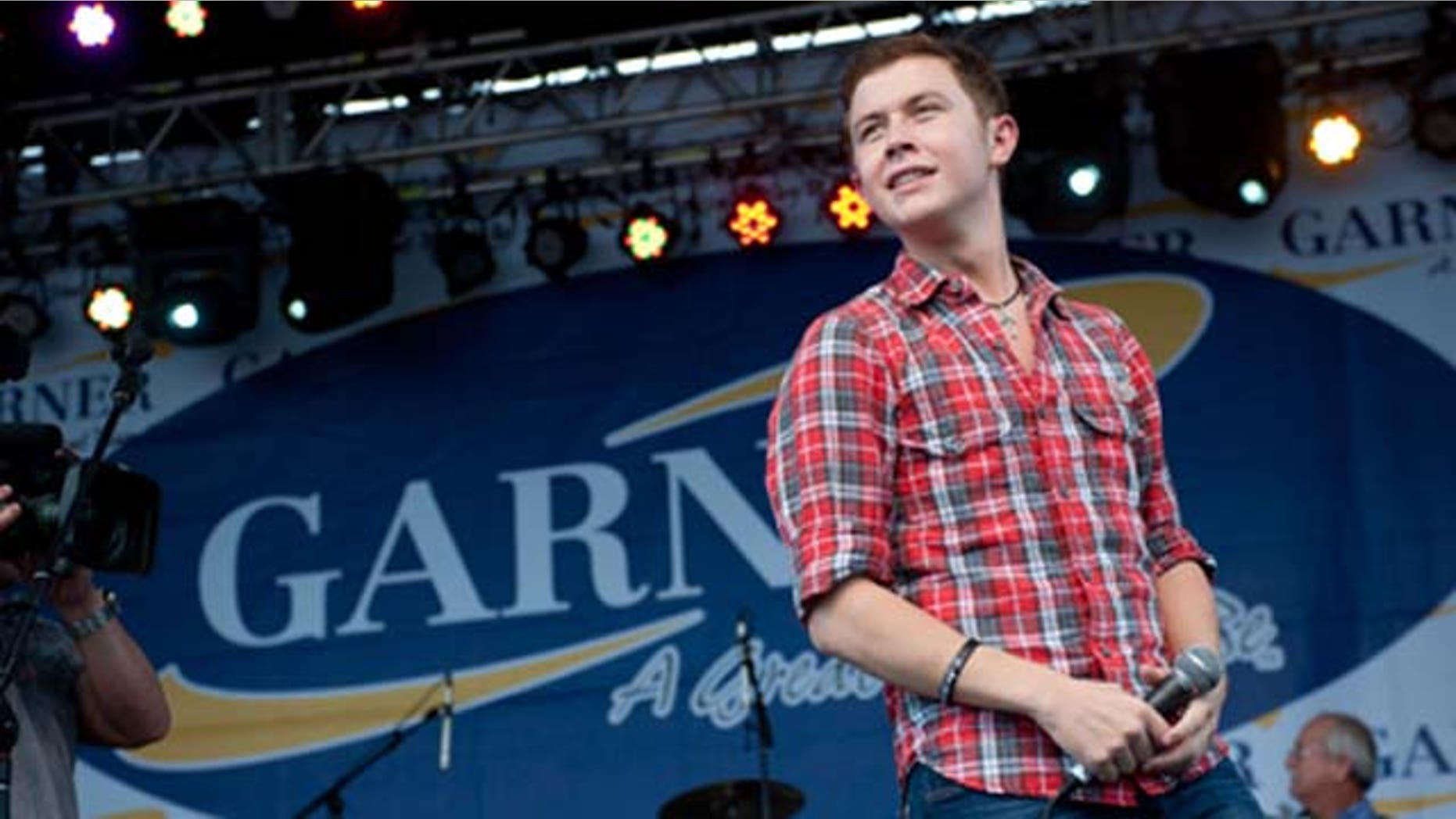 GARNER, NC - MAY 14: American Idol" finalist Scotty McCreery performs at an outdoor concert for adoring local fans at his homecoming celebration at Buffaloe Park May 14, 2011 in Garner, North Carolina. In the past six weeks, McCreery has gone from being a cashier at Lowes Foods and a singer known only around the Triangle to being a national if not global phenomenon on "American Idol." Residence and town officials prepared a hometown hero's welcome for McCreery two days after he advanced to become one of three top finalist in season ten of America Idol. (Photo by Steve Exum/Getty Images)