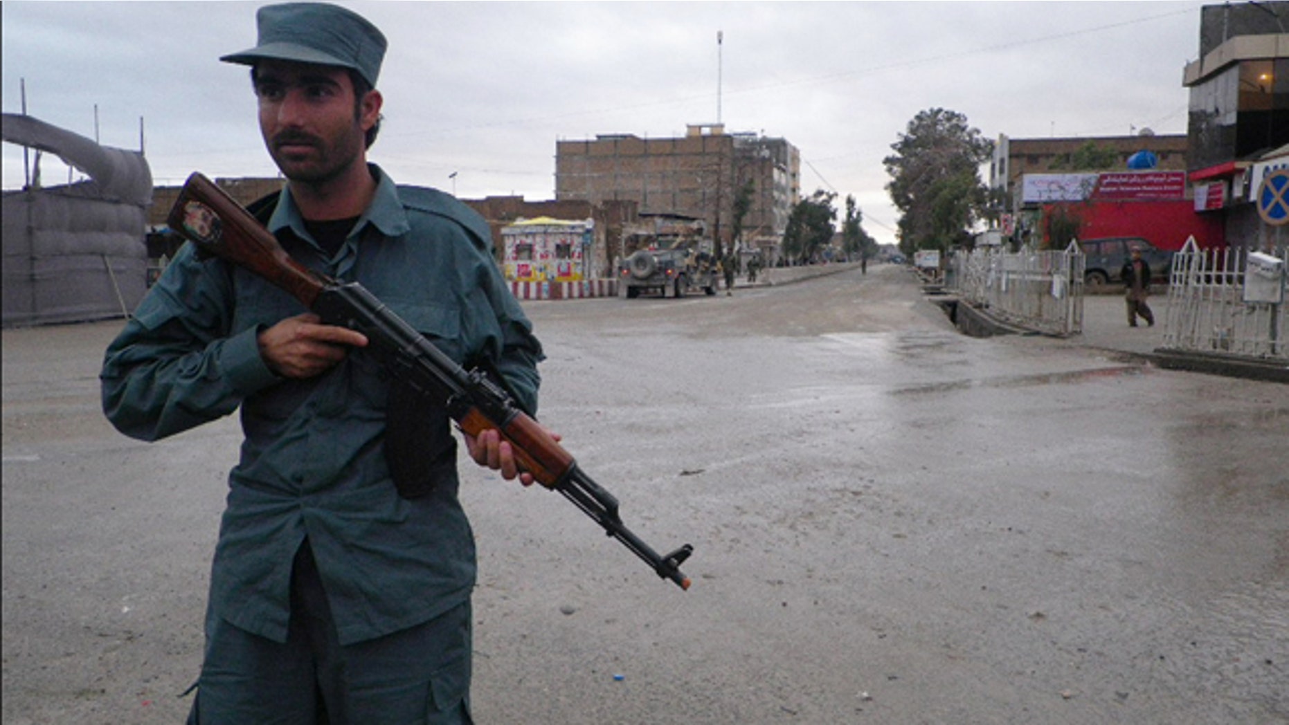 FILE: An Afghan policeman stands guard on the road leading to the Kandahar police headquarters in Kandahar south of Kabul, Afghanistan.