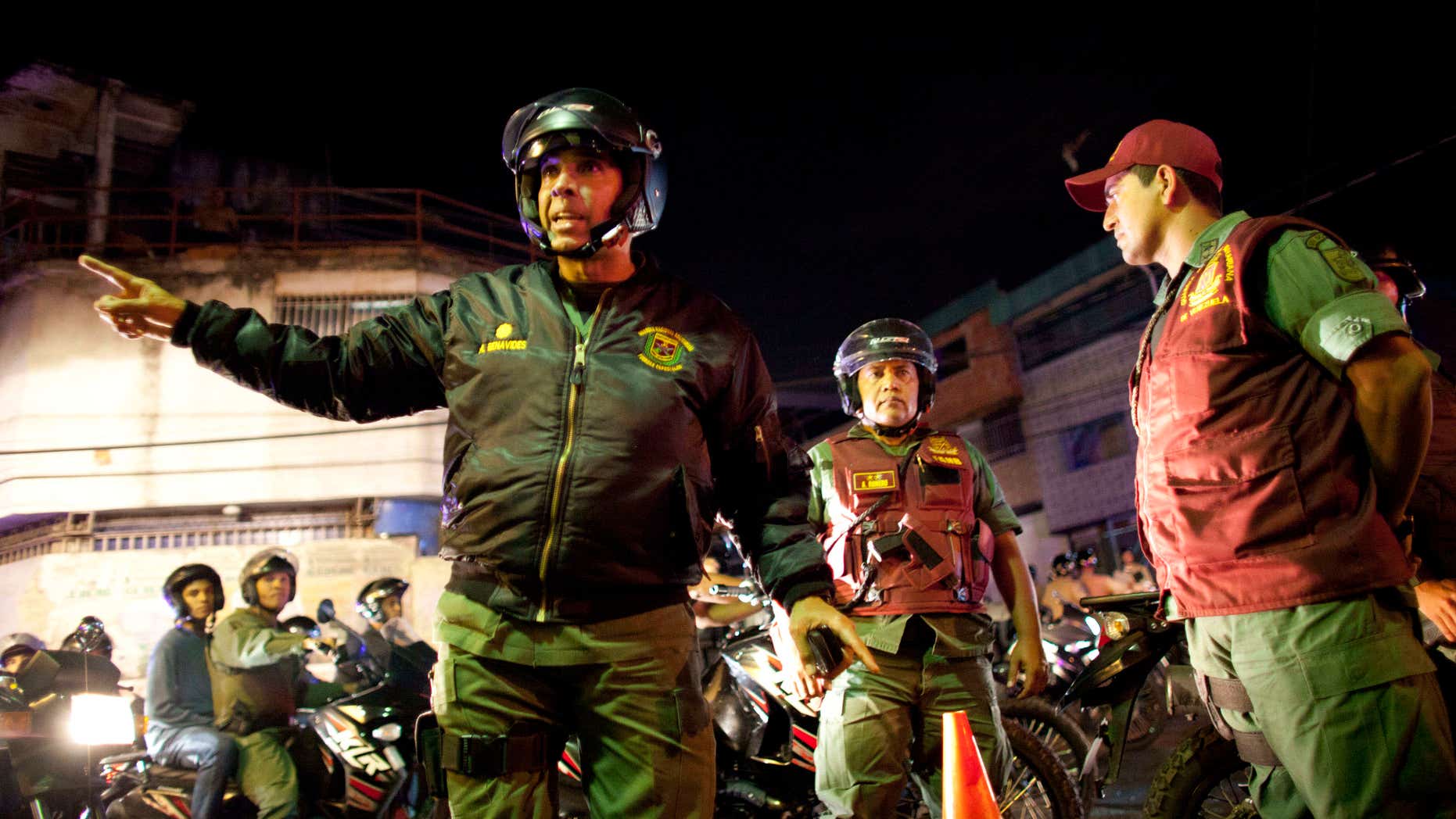In this May 14, 2013 photo, Gen. Antonio Benavides, left, gives instructions to a soldiers during a security operation that is part of the "Secure Homeland" initiative in Petare, one of the most dangerous neighborhoods of Caracas, Venezuela. The murder rate doubled during the 14-year-rule of the late President Hugo Chavez as cheap access to guns and an ineffective justice system fed a culture of violence in slums like Petare, parts of which have become no-go zones for outsiders, including police. (AP Photo/Ariana Cubillos)