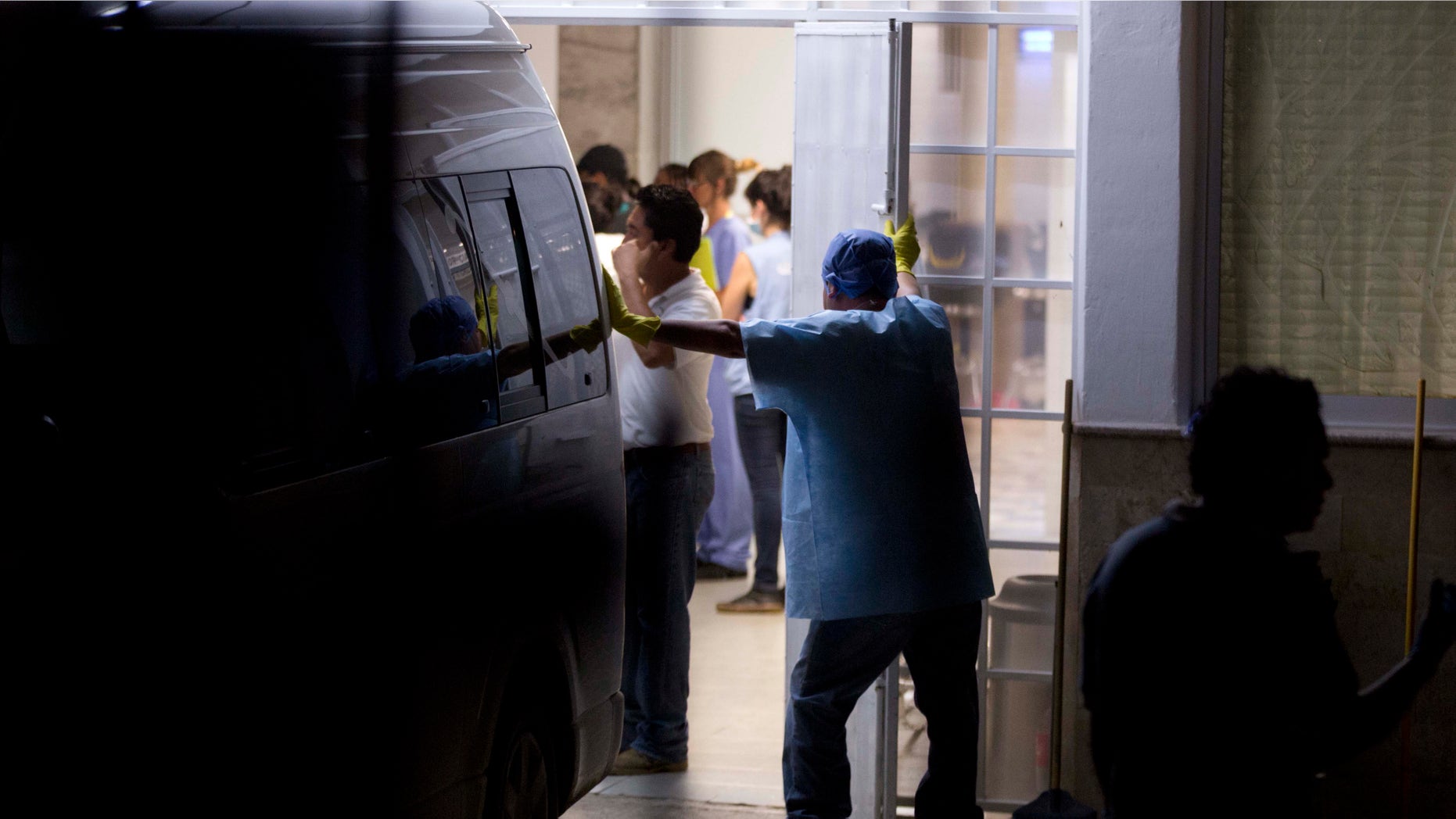 A forensic workers stand inside of the morgue in Iguala Mexico, Sunday Oct. 5, 2014. Mexican forensic experts recovered 28 charred bodies from a clandestine grave on the outskirts of this city where police engaged in a deadly clash with student protesters a week ago, Guerrero state's chief prosecutor said Sunday. Authorities said the corpses were too badly damaged for immediate identification and he could not say whether any of the dead could be some of the 43 college students reported missing after the confrontation with police. (AP Photo/Eduardo Verdugo)