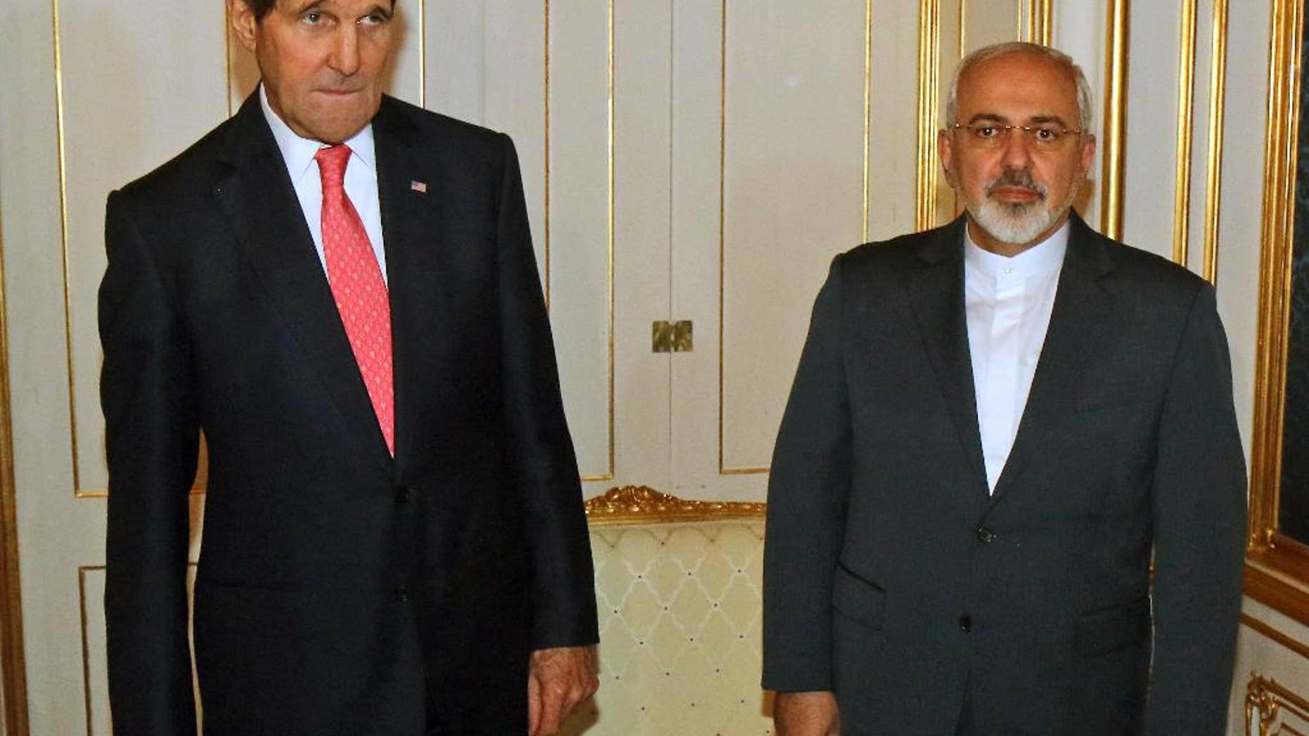 FILE - In this Nov. 23, 2014 file photo, U.S. Secretary of State John Kerry and Iranian Foreign Minister Mohammad Javad Zarif, right, pose for a photograph prior to a bilateral meeting of the closed-door nuclear talks in Vienna, Austria. Diplomats say Iran and the U.S. have tentatively agreed that Tehran will ship to Russia much of the material it could use to manufacture nuclear weapons. (AP Photo/Ronald Zak, Pool-File)