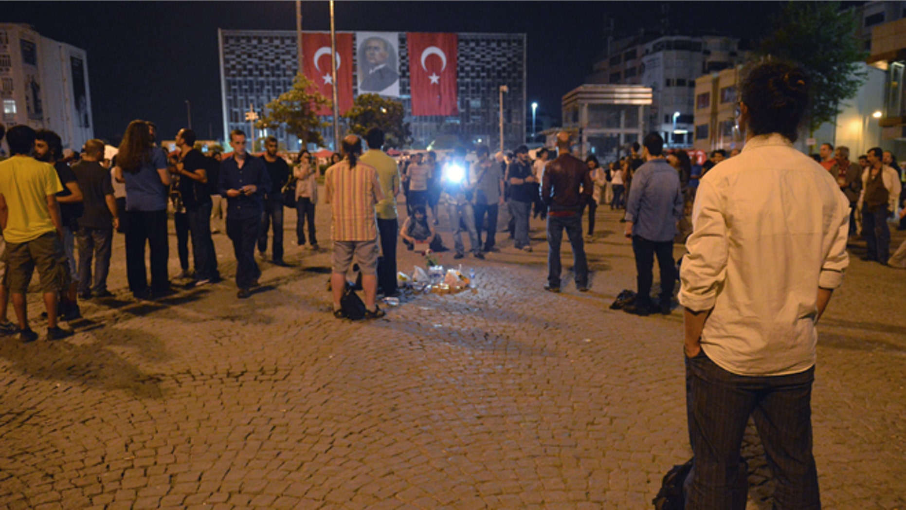 Erdem Gunduz, right, stands silently on Taksim Square in Istanbul, Turkey, early Tuesday, June 18, 2013. After weeks of confrontation with police, sometimes violent, Turkish protesters are using a new form of resistance: standing silently. The development started late Monday when a solitary man began standing in passive defiance against Prime Minister Recep Tayyip Erdogan's authority at Istanbul's central Taksim Square. The square has been sealed off from mass protests since police cleared it over the weekend. The man has identified himself as Erdem Gunduz, a performance artist. His act has sparked imitation by others in Istanbul and other cities. It has provoked widespread comment on social media. (AP Photo)