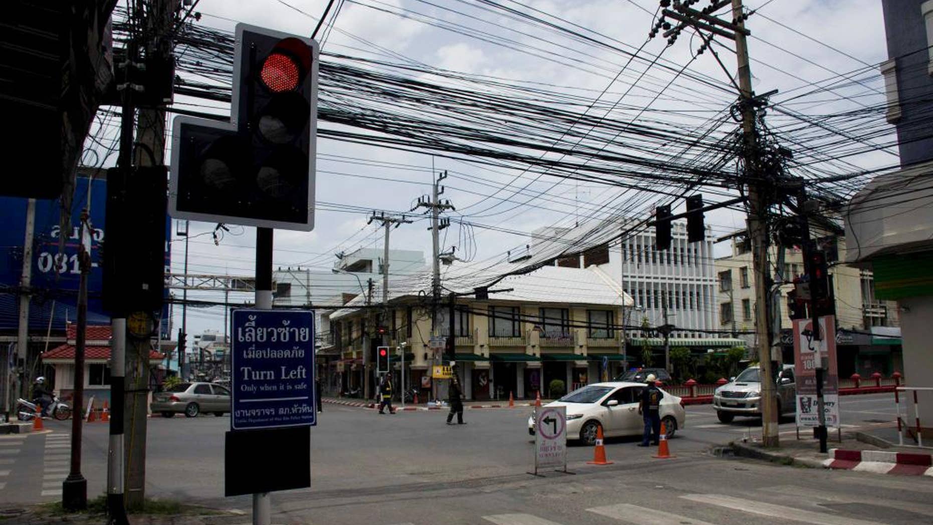 Authorities direct traffic after explosions occurred overnight and Friday morning in the tourist city of Hua Hin, Thailand on Friday, Aug. 12, 2016. The city is home to a swath of beachfront resorts as well as a royal palace. A wave of coordinated explosions rattled multiple cities across southern Thailand, killing at least four people and wounding dozens more, police said Friday. (AP Photo/Penny Yi Wang)
