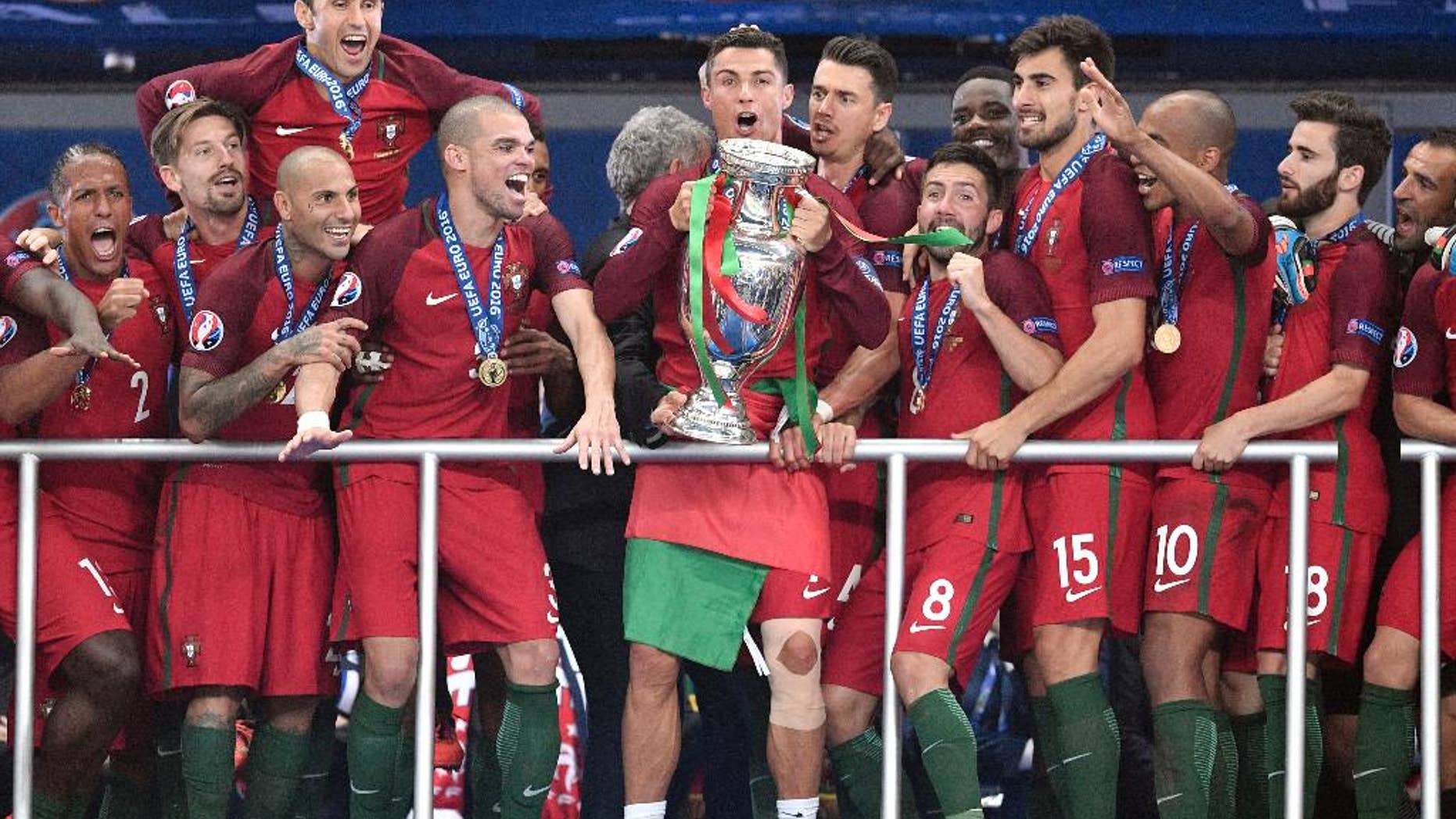 Portugal's Cristiano Ronaldo holds the trophy after winning the Euro 2016 final soccer match between Portugal and France at the Stade de France in Saint-Denis, north of Paris, Sunday, July 10, 2016. (AP Photo/Martin Meissner)