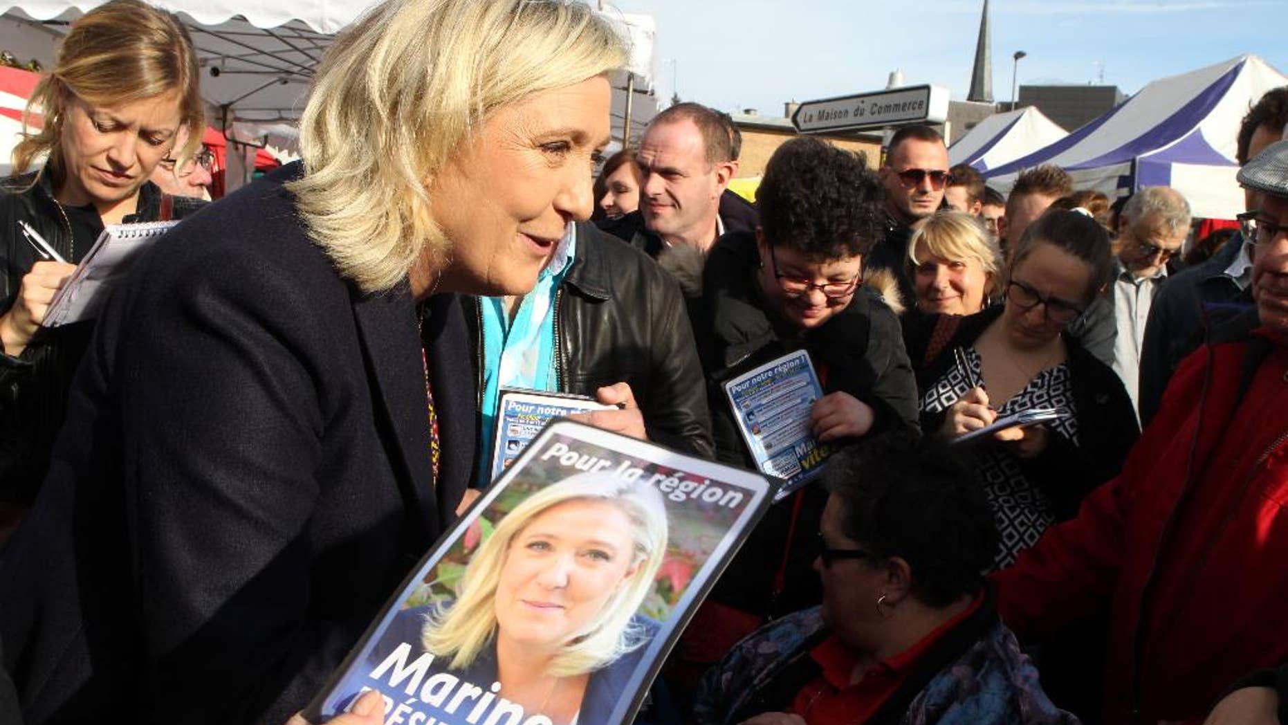 French far-right party leader Marine Le Pen meets residents in a marketplace, in Douai, northern France, as part of the municipal campaign, Saturday, Nov. 7, 2015. Regional elections are taking place next month in which the far right National Front is hoping to increase its political power, in part by capitalizing on tensions over waves of migrants in Europe this year. The first round of the regional elections will take place on Dec. 6, 2015. (AP Photo/Michel Spingler)