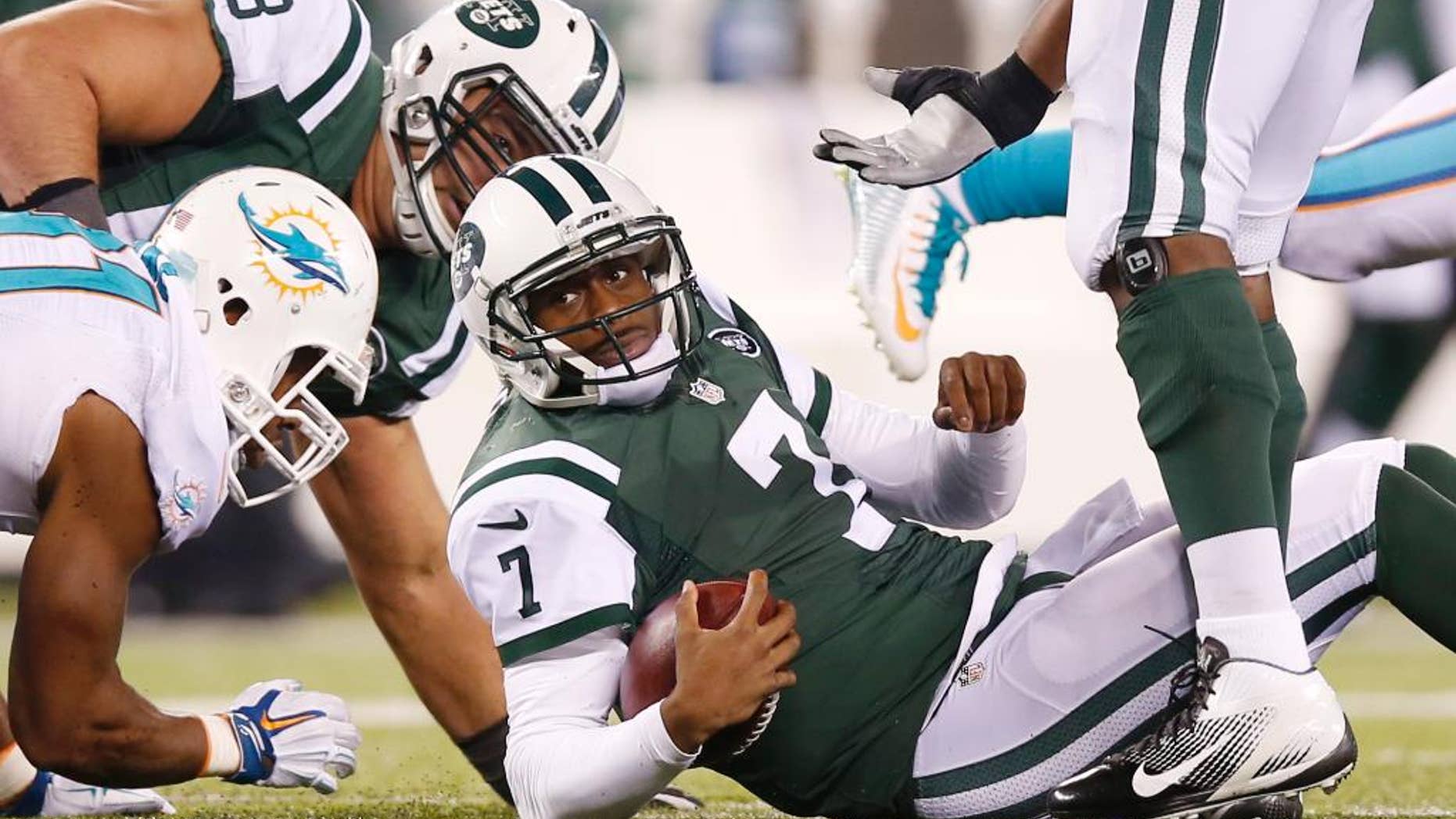 New York Jets quarterback Geno Smith (7) reacts after being sacked by the Miami Dolphins during the fourth quarter of an NFL football game, Monday, Dec. 1, 2014, in East Rutherford, N.J. (AP Photo/Kathy Willens)