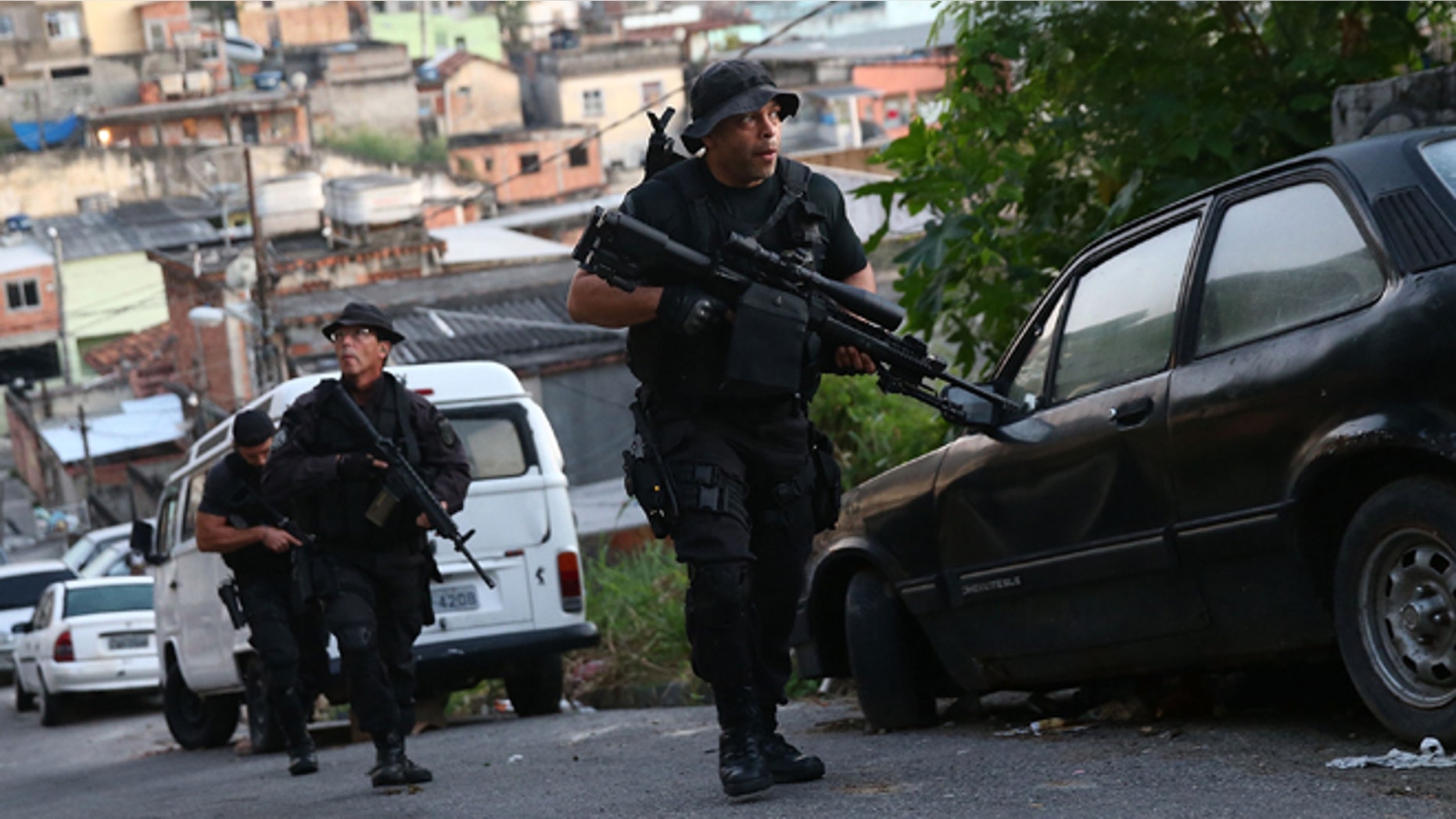 RIO DE JANEIRO, BRAZIL - MAY 13: Officers from the CORE police special forces patrol during an operation to search for fugitives in the Complexo do Alemao pacified community, or 'favela' on May 13, 2014 in Rio de Janeiro, Brazil. Ahead of the 2014 FIFA World Cup, Rio has seen an uptick in violence in its pacified slums. A total of around 1.6 million Rio residents live in shantytowns, many of which are controlled by drug traffickers. (Photo by Mario Tama/Getty Images)
