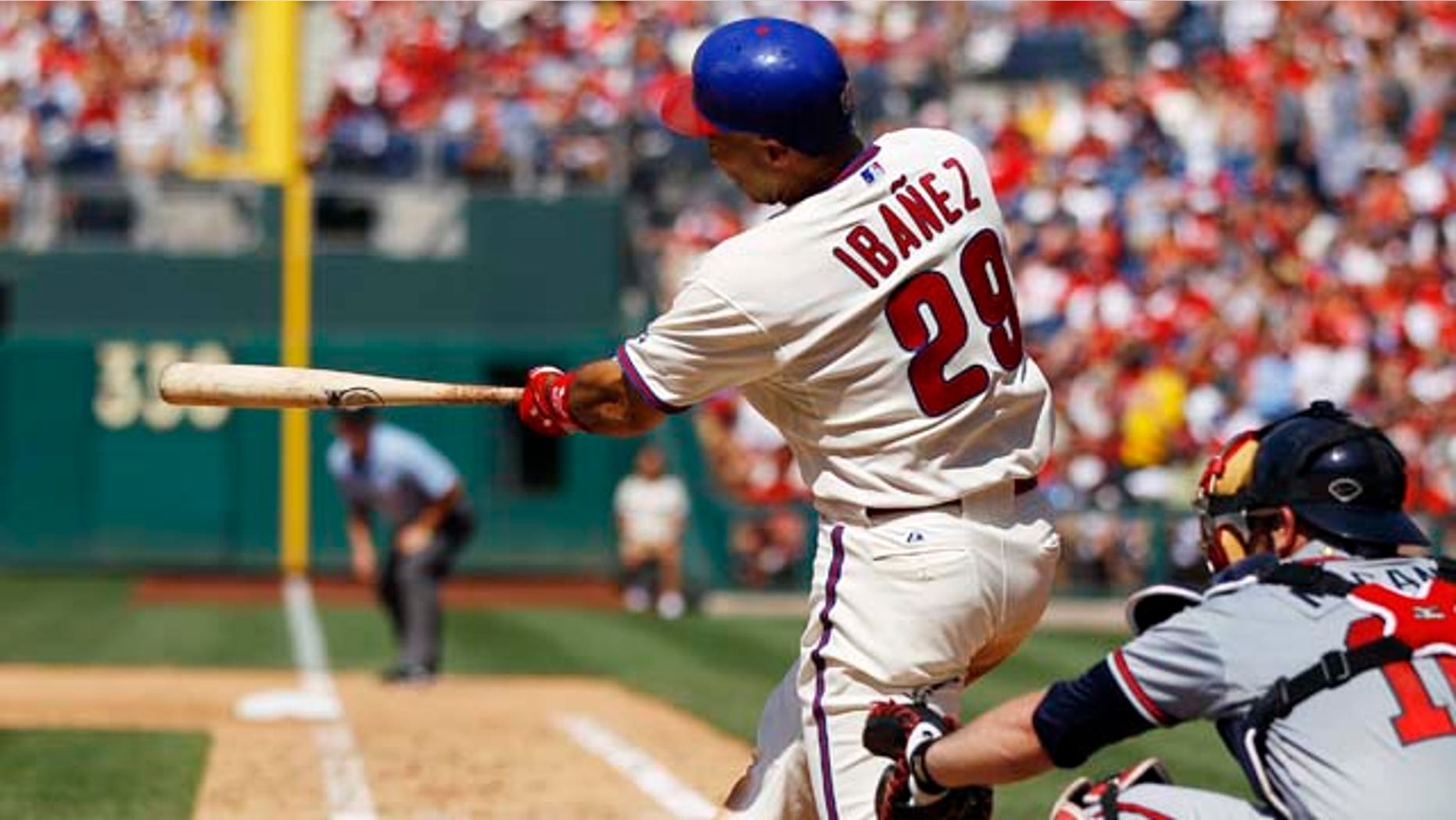 Philadelphia Phillies' Raul Ibanez follows through on a two-run single in the seventh inning of a baseball game against the Atlanta Braves, Sunday, July 10, 2011, in Philadelphia. At right is Braves catcher Brian McCann. The Phillies won 14-1. (AP Photo/Matt Slocum)