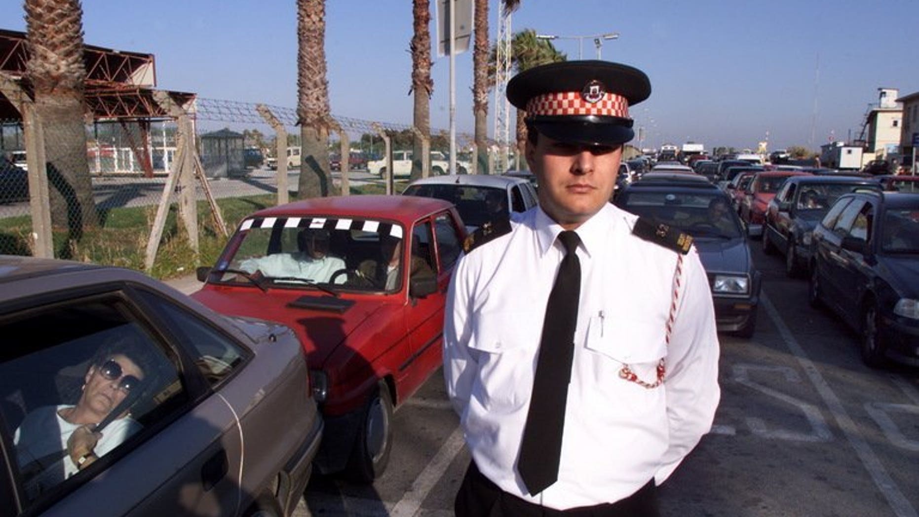 File picture shows a policeman monitoring traffic as cars wait to cross from Gibraltar into Spain. The government said Sunday it had "serious concerns" after Gibraltar accused Madrid of deliberately creating delays to car traffic to and from the disputed British-held territory to Spain.