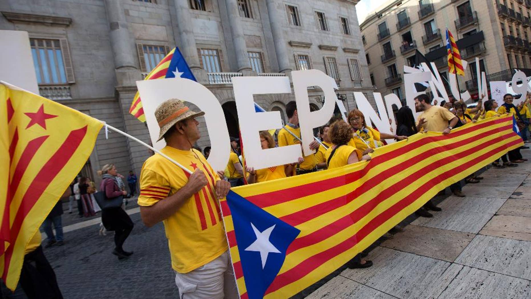 Pro independence supporters gather outside the Generalitat Palace, the main head office of the Government of Catalonia, as Catalonia's regional president Artur Mas, signs the decree to call the referendum in Catalonia in Barcelona, Spain, Saturday, Sept. 27, 2014. The president of Spain's powerful northeastern region of Catalonia on Saturday formally called an independence referendum Nov. 9, the latest secession push in Europe and one of the most serious challenges to the Spanish state of recent years. (AP Photo/Jordi Borras)