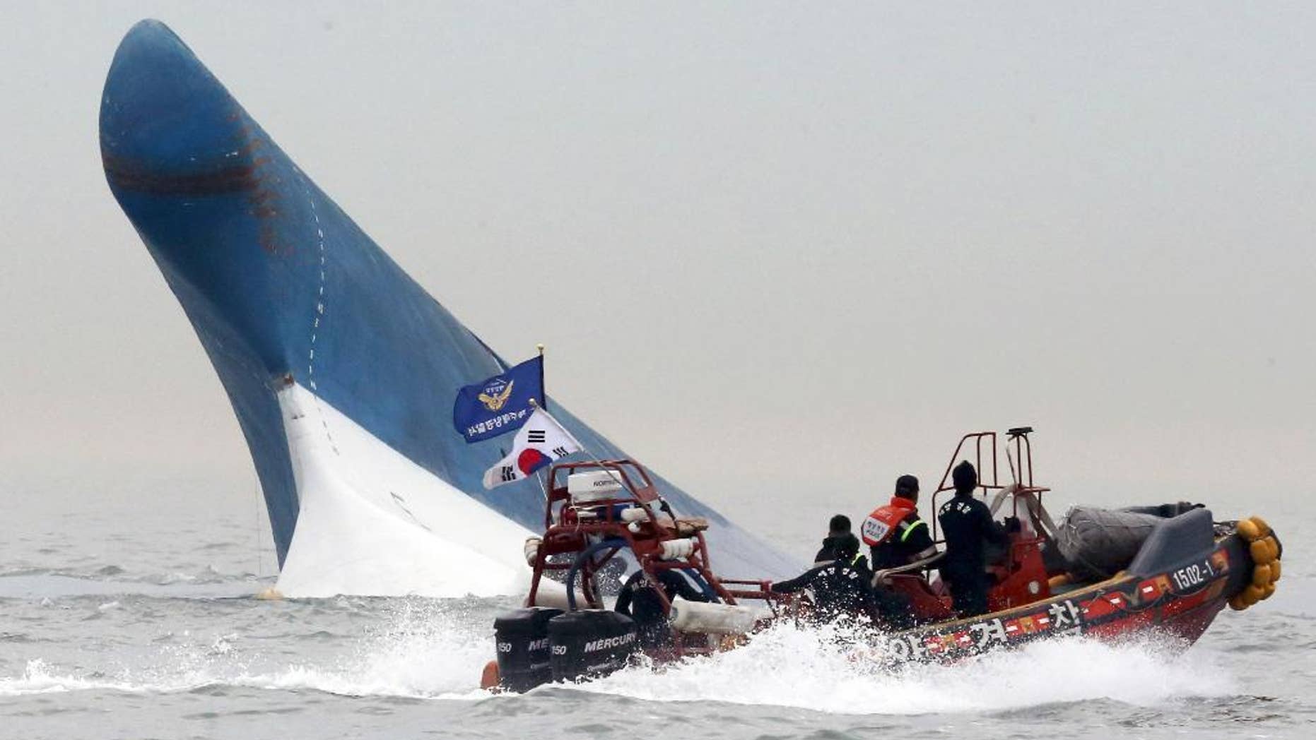 FILE - In this April 16, 2014 file photo, South Korean coast guard officers try to rescue passengers from the Sewol ferry as it sinks in the water off the southern coast near Jindo, south of Seoul, South Korea. It is a decision that has maritime experts stumped and is at odds with standard procedure: Why were the passengers of the doomed South Korean ferry told to stay in their rooms rather than climb on deck? Evacuations can be chaotic and dangerous, and an important principle in maritime circles is that even a damaged ship may be the best lifeboat. But car ferries like the Sewol, which left some 300 people missing or dead when it sank Wednesday, are different. They are particularly susceptible to rapid capsizing which makes it critically important that the crew quickly evacuate passengers when there is trouble. (AP Photo/Yonhap, File) KOREA OUT