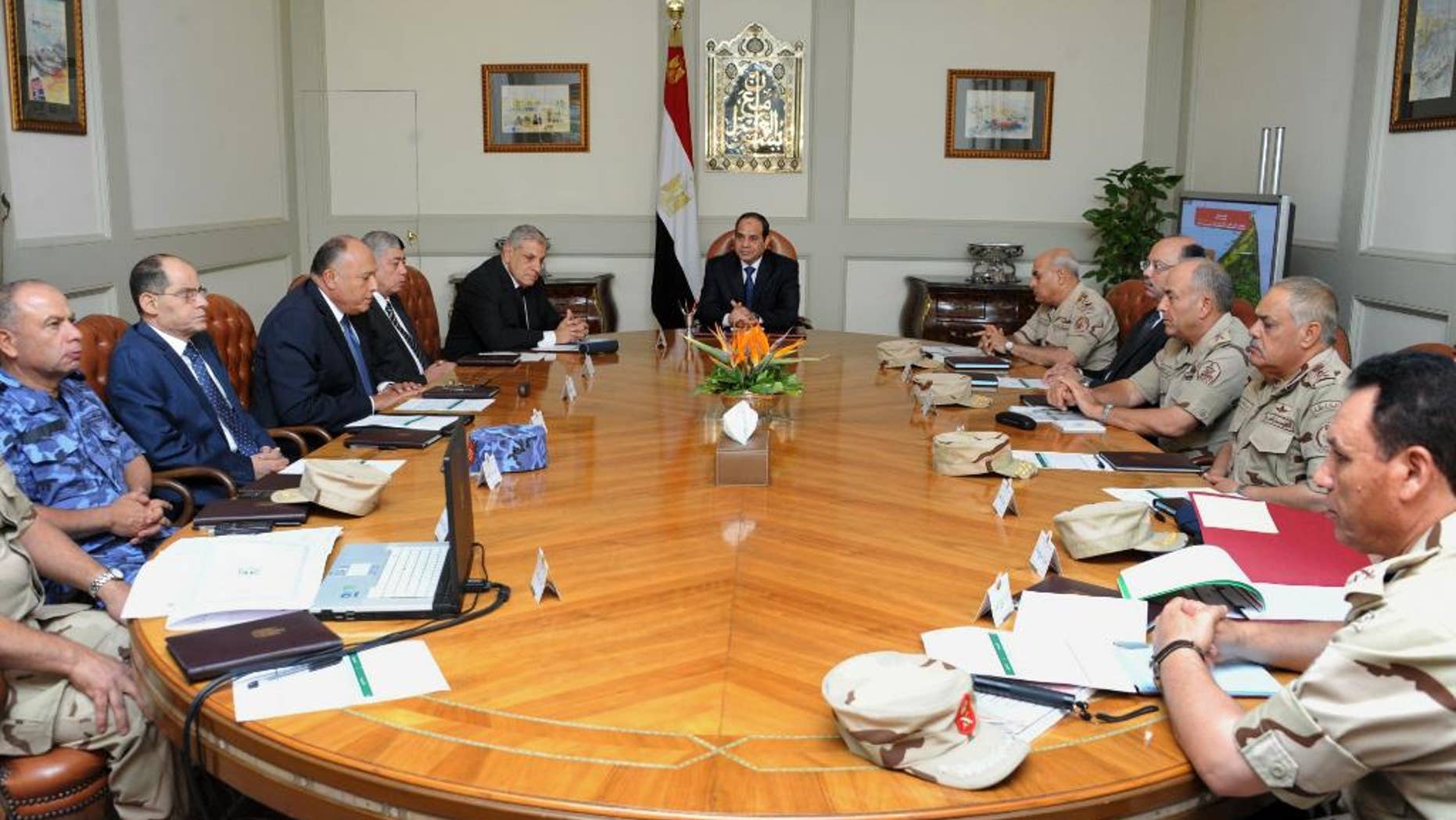 In this photo provided by Egypt's state news agency MENA, Egypt's President Abdel-Fattah el-Sissi, center, holds an emergency meeting of the National Defense Council with top officials after an attack in the Sinai Peninsula, in Cairo, Egypt, Friday, Oct. 24, 2014. The coordinated assault on an army checkpoint in the Sinai Peninsula killed 30 Egyptian troops on Friday, making it the deadliest single attack in decades on the military, which has been struggling to stem a wave of violence by Islamic extremists since the overthrow of Islamist President Mohammed Morsi. El-Sissi, the former defense minister and army chief who overthrew Morsi last year, declared a three-day mourning period. (AP Photo/MENA)