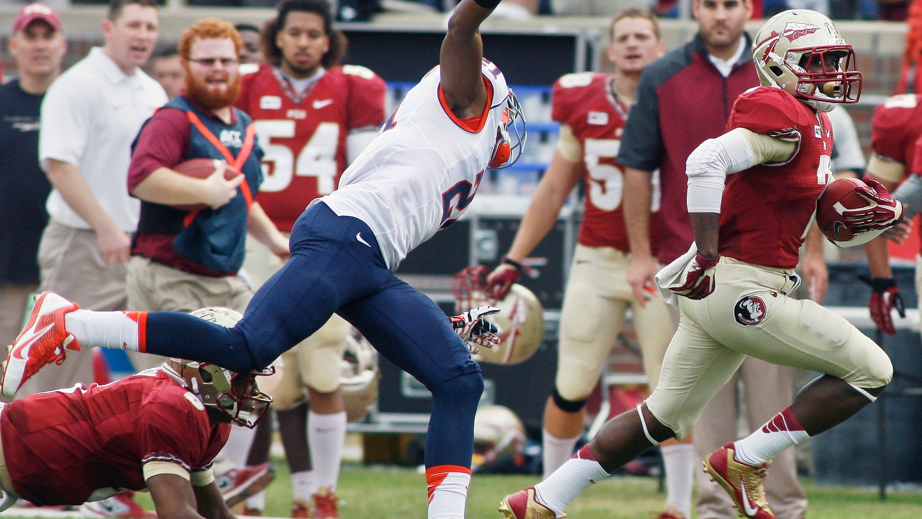 Florida State quarterback Jameis Winston, left, (5) throws a block to take out Syracuse cornerback Julian Whigham (21), allowing running back Kermit Whitfield (7) to score a 74-yard touchdown in the first quarter of an NCAA college football game on Saturday, Nov. 16, 2013, in Tallahassee, Fla. (AP Photo/Phil Sears)