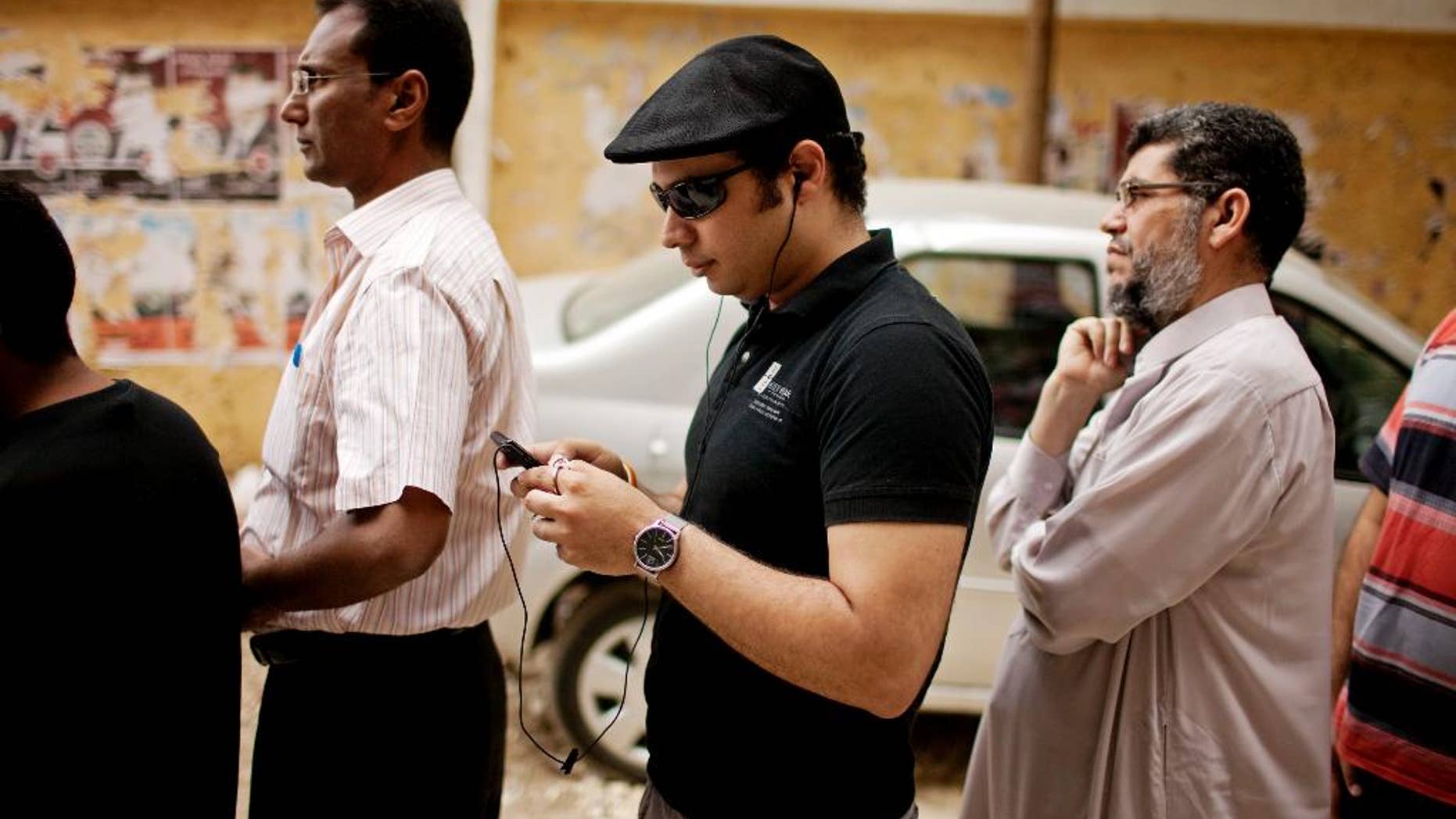 FILE -- In this May 23, 2012 file photo, Ahmed Maher, a co-founder of the April 6 Revolutionary Movement, waits in line to vote in presidential elections after 16 months of interim rule by the Supreme Council of Armed Forces, at a polling center in Cairo, Egypt. Maher, a leading Egyptian activist behind the 2011 uprising that toppled Hosni Mubarak has been released from prison after serving a three-year sentence for violating a ban on unauthorized protests. A lawyer for Maher, Tarek al-Awadi, said Maher will be under surveillance for the next three years as part of his sentence. (AP Photo/Pete Muller, File)