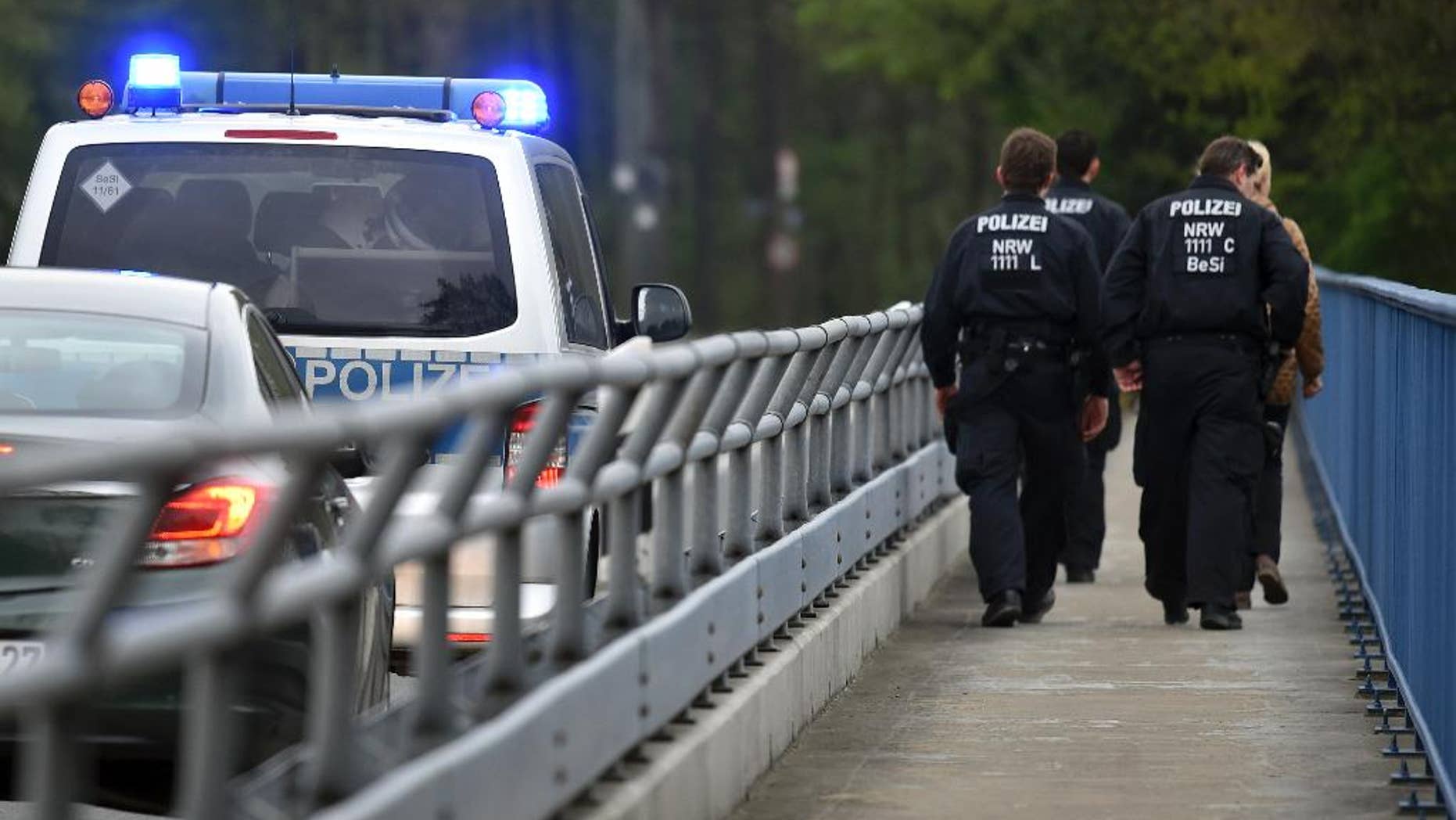 Policemen are on their way to search for evidence in Dortmund, Germany, Friday, April 14, 2017. After the attack on the team bus of Borussia Dortmund soccer club Tuesday, April 11, 2017, the used explosives and the ignition mechanism are in focus of the investigations (Caroline Seidel/dpa via AP)
