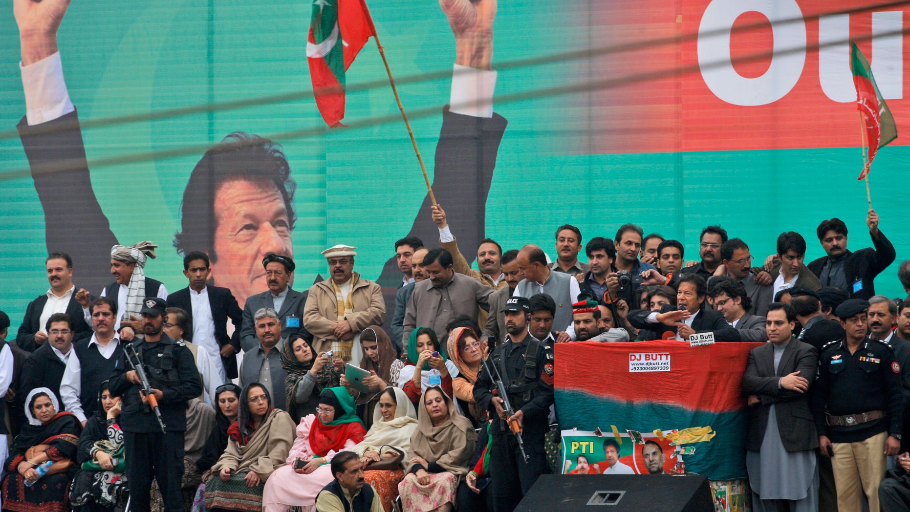 Nov. 23, 2013: Pakistan's cricketer-turned politician Imran Khan, leader of Pakistan Tehreek-e-Insaf party, with a microphone at center right, surrounded by security men and party members, delivers a speech to his supporters during a protest against U.S. drone strikes in Pakistan, in Peshawar, Pakistan. Thousands of people protesting U.S. drone strikes blocked a road in northwest Pakistan on Saturday used to truck NATO troop supplies and equipment in and out of Afghanistan, the latest sign of rising tension caused by the attacks.