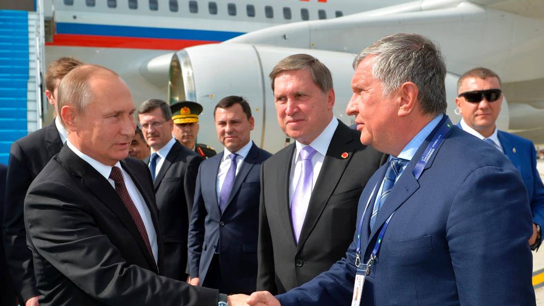 Russian President Vladimir Putin, left, shakes hands with CEO of state-controlled Russian oil company Rosneft Igor Sechin, right, as he arrives to attend a session of the World Energy Congress, in Istanbul, Monday, Oct. 10, 2016. Putin is set to meet Erdogan as the two push ahead with steps toward normalizing ties that were strained by Turkey's downing of a Russian warplane near the border with Syria last year. (Alexei Druzhinin, Sputnik, Kremlin Pool Photo via AP)