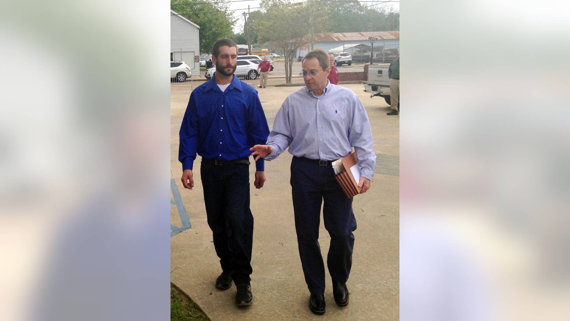 Christopher Few, left, walks with attorney Mark Jeansonne to the courthouse in Marksville, La., Tuesday, March 21, 2017. Derrick Stafford, a Louisiana law enforcement officer, is charged with murder in the shooting death of Few's 6-year-old autistic. Few was also wounded in the shooting. (AP Photo/Michael Kunzelman)