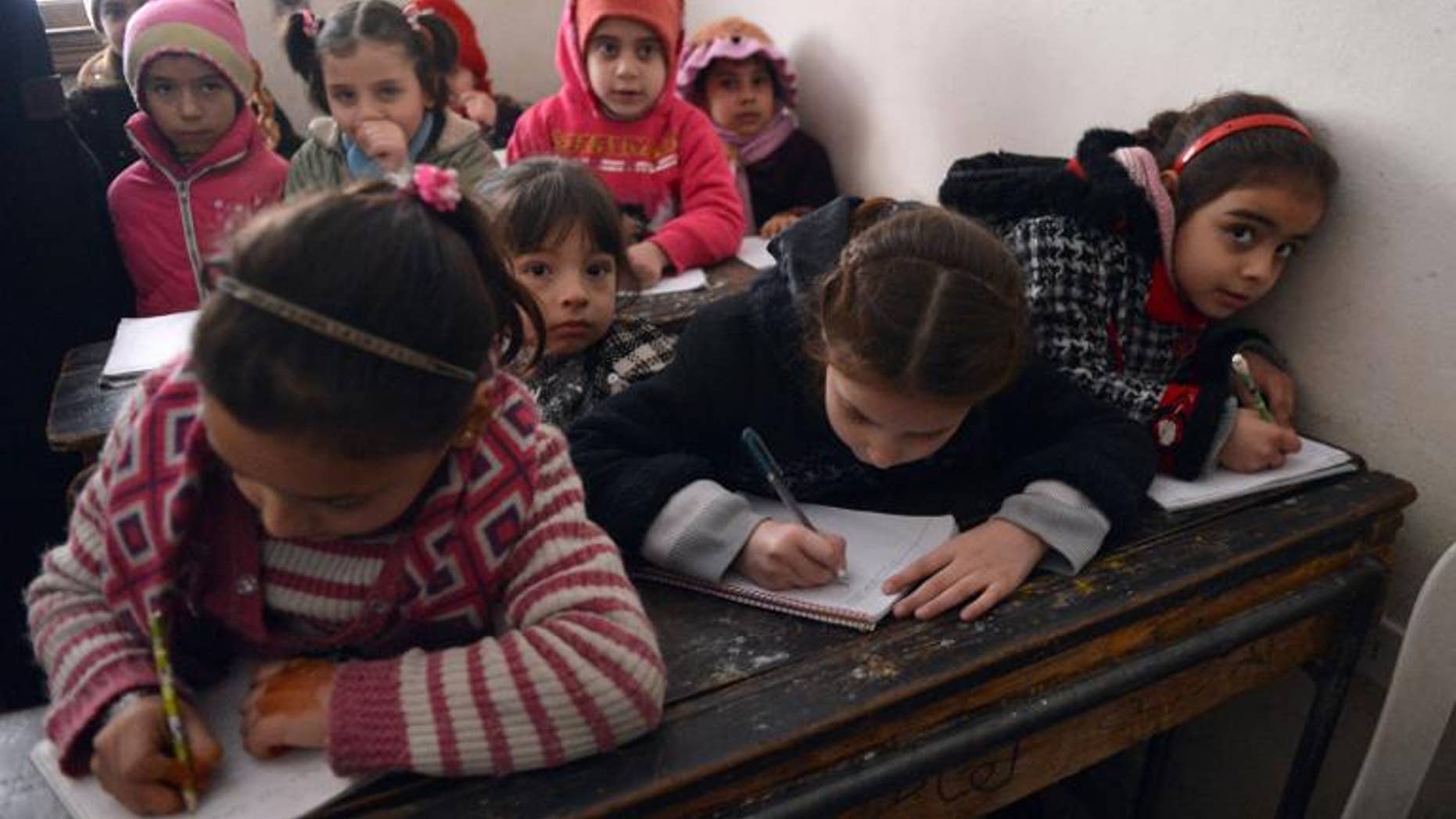 Syrian children attend a class at a school in the Kadi Askar area in the Syria's northern city of Aleppo on February 9, 2013.