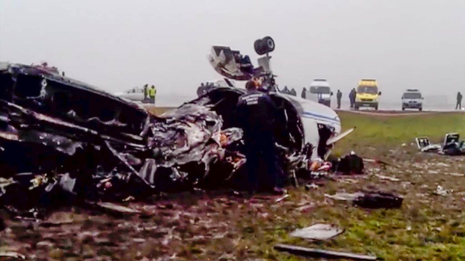 In this image made from video provided by Russian State Television Rossiya, investigators works at the wreckage of a private jet which collided with a snowplow at Vnukovo airport in Moscow, Tuesday, Oct. 21, 2014. The head of French oil giant Total SA and three French crew members were killed at Vnukovo airport when a corporate jet, the French-made Dassault Falcon 50, collided with a snowplow, Russian investigators said Tuesday. (AP Photo) TV OUT