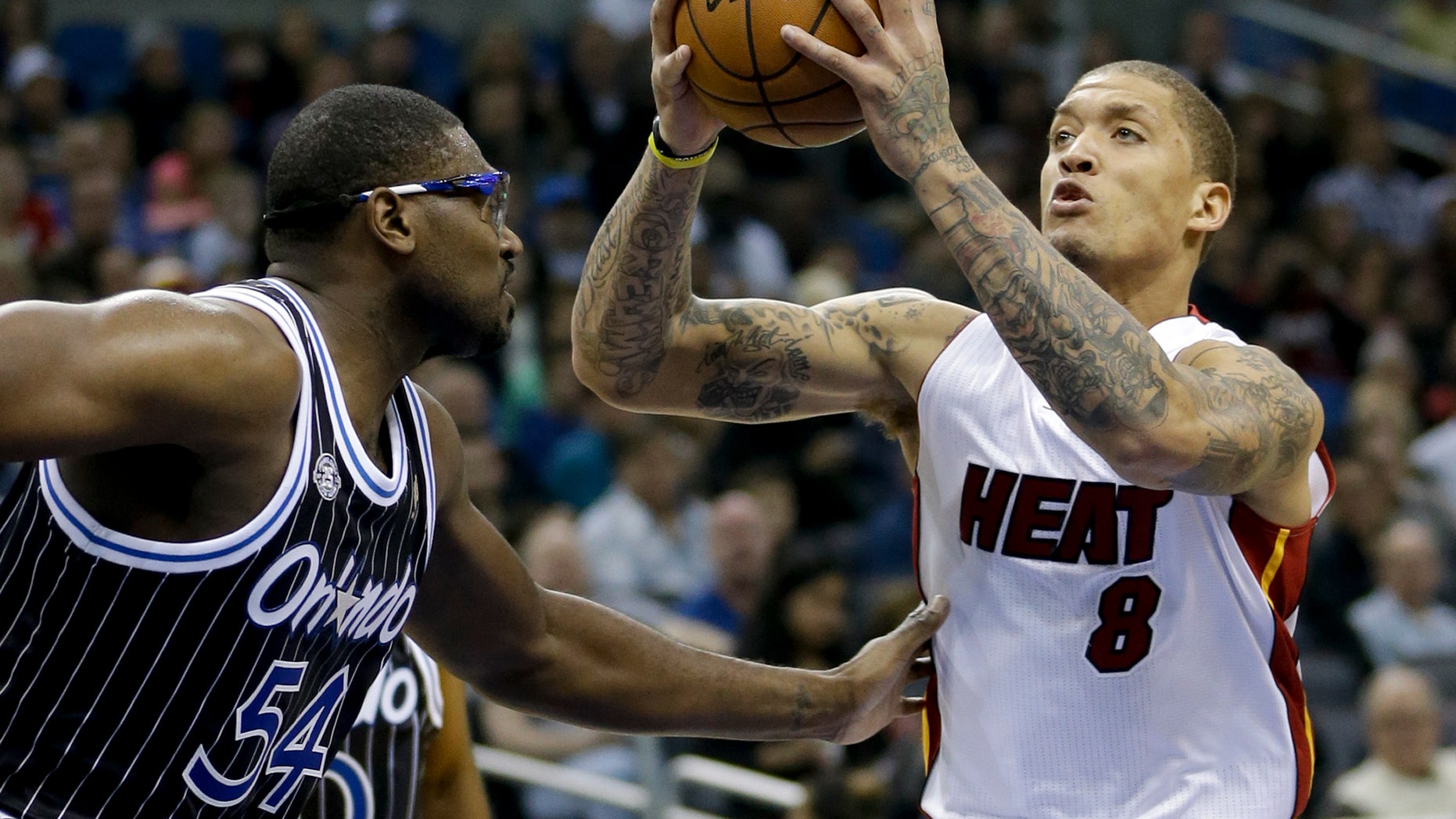 Miami Heat's Michael Beasley (8) goes up for a shot as he is defended by Orlando Magic's Jason Maxiell (54) during the first half of an NBA basketball game, Saturday, Jan. 4, 2014, in Orlando, Fla. (AP Photo/John Raoux)