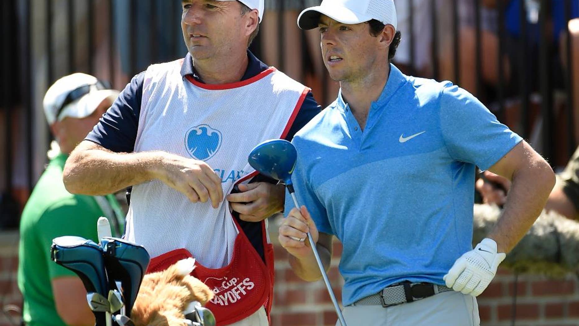 In this Aug. 28, 2016 photo, Rory McIlroy of Northern Ireland, right, and his caddy, J. P. Fitzgerald look down the fairway before McIlroy tees off from the first hole during the final round of The Barclays golf tournament in Farmingdale, N.Y.. McIlroy didn't have to check his bank account to know that his FedEx Cup bonus had been deposited. His caddie, J.P. Fitzgerald, informed him with a text message that a 'tsunami' had hit his account. McIlroy paid him a bonus of just over $1 million. "I think his words were, 'A tsunami just hit my bank account, so thank you very much,'" McIlroy said Wednesday, Oct. 26, 2016, on the eve of the HSBC Champions. (AP Photo/Kathy Kmonicek)