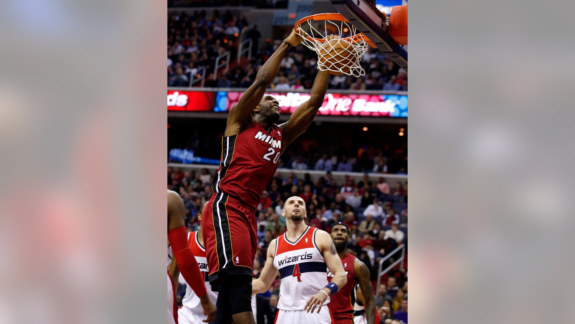 Miami Heat center Greg Oden (20) dunks the ball in front of Washington Wizards center Marcin Gortat (4), from Poland, in the first half of an NBA basketball game on Wednesday, Jan. 15, 2014, in Washington. It was Oden's first NBA regular-season game in more than four years. (AP Photo/Alex Brandon)