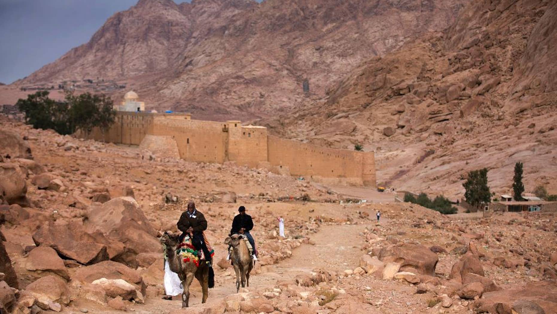FILE -- In this Dec. 9, 2013 file photo, visitors leave Saint Catherine's Monastery on camels, in Saint Catherine, Egypt. The Islamic State extremist group said Tuesday, April 18, 2017, that its militants carried an attack on a police checkpoint near the famed Monastery in Sinai, which Egyptian security authorities said killed one policeman and wounded four. The attack on the monastery, built in the 6th century and a popular site for tourists visiting the Red Sea resorts along Sinai's southern coast, comes just over a week after suicide bombers attacked two churches in the Nile Delta city of Tanta and the coastal city of Alexandria, killing 45 people on Palm Sunday. (AP Photo/Hiro Komae, File)