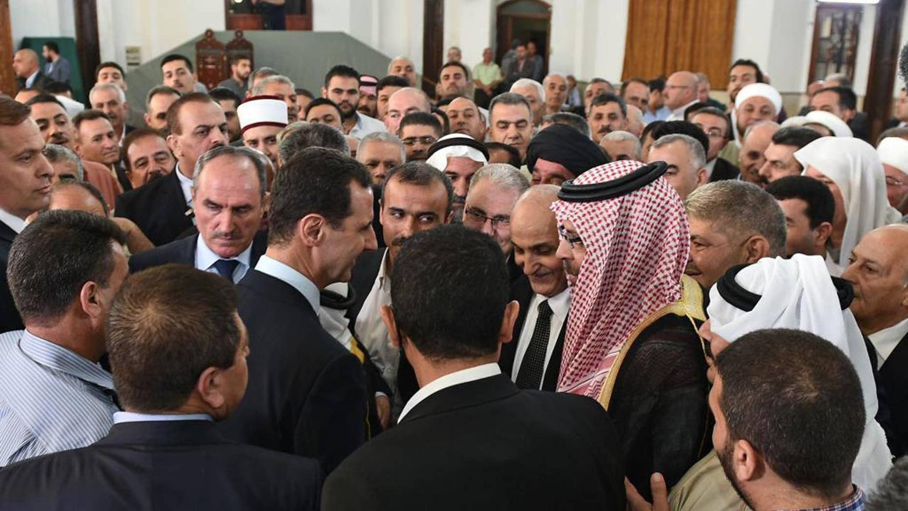 In this photo released on the official Facebook page of the Syrian Presidency, Syrian President Bashar Assad, greets people at the Safa Mosque on the first day of Eid al-Fitr, that marks the end of the Muslim holy month of Ramadan, in Homs, Syria, Wednesday, July 6, 2016. (Syrian Presidency via AP)