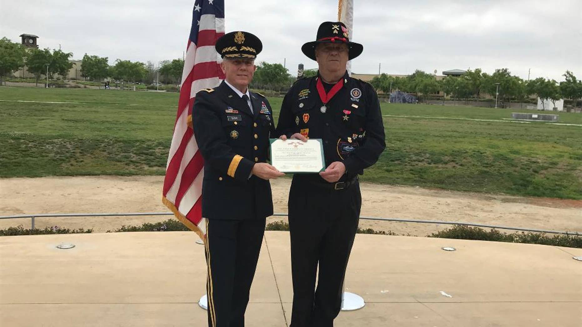 In this Monday, March 20, 2017, photo provided by the California Army National Guard, former Army Maj. Gen. Juilian Burns, left, presents retired U.S. Army Sgt. Joseph Engles with the Bronze Star during a ceremony in his hometown of Murrieta, Calif. Engles received the honor for gallantry in the face of the enemy during the Battle of Suoi Tre, Vietnam in March 1967. (Capt. Will Martin/California Army National Guard via AP)