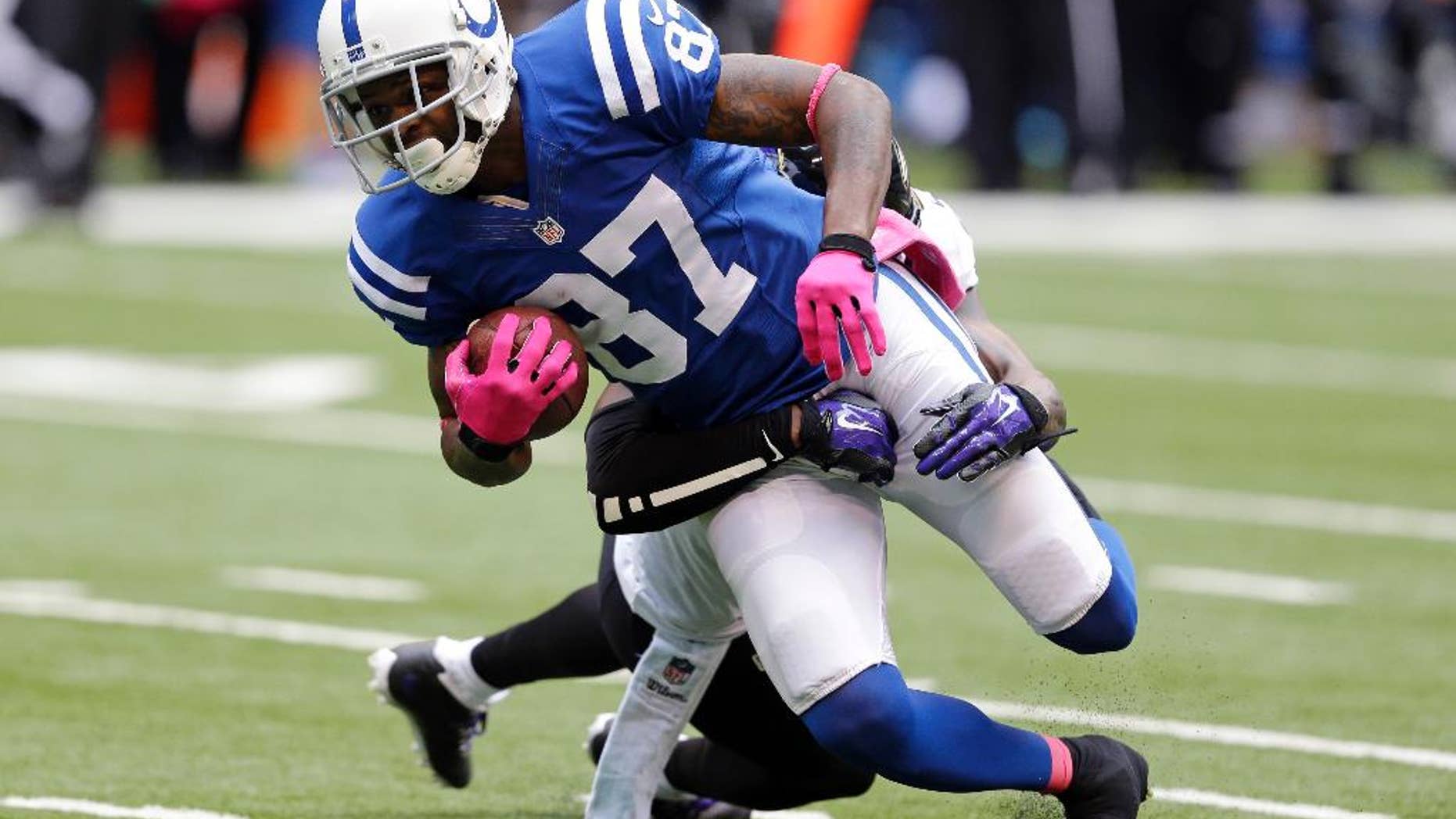 Indianapolis Colts wide receiver Reggie Wayne (87) is tackled by Baltimore Ravens free safety Darian Stewart after a first down during the first half of an NFL football game in Indianapolis, Sunday, Oct. 5, 2014. (AP Photo/Michael Conroy)