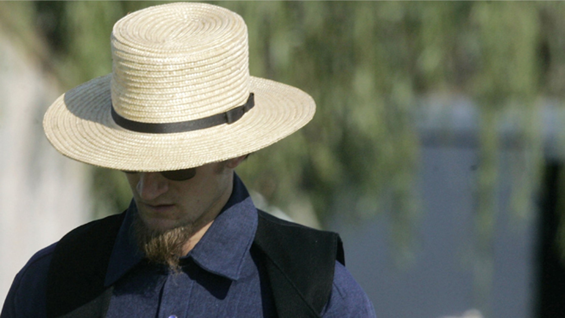NICKEL MINES, PA - OCTOBER 03: A member of the Amish community walks to the home of one of the girls that was killed yesterday at the one room Amish schoolhouse shooting October 3, 2006 in Nickel Mines, Pennsylvania. According to officials a milk truck driver identified as Charles Carl Roberts IV entered the schoolhouse, let the boys and adults go free, tied up the girls and shot them execution style before committing suicide. Five girls were killed and at least seven others injured. (Photo by Mark Wilson/Getty Images)