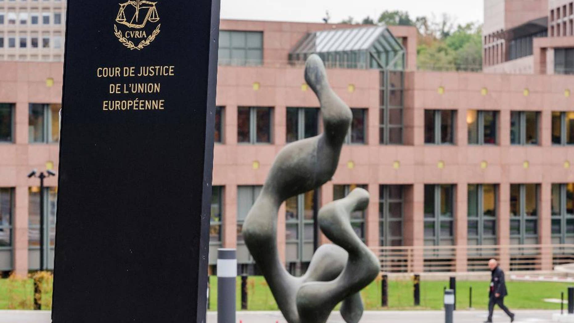 FILE - In this Oct. 5, 2015 file photo, a man walks by the European Court of Justice in Luxembourg. The European Court of Justice ruled on Tuesday, Jan. 31, 2017, that an asylum request can be rejected if the person seeking protection has links to a terrorist group. (AP Photo/Geert Vanden Wijngaert, File)