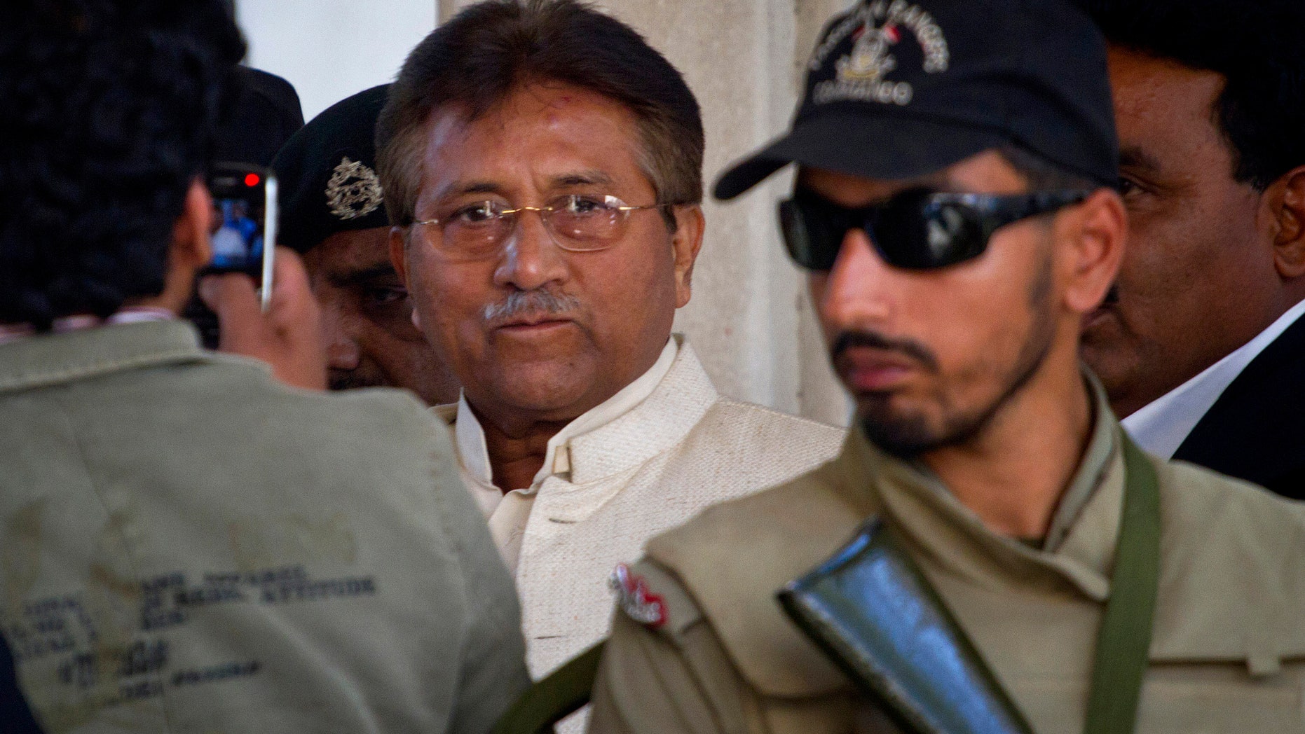 FILE -- In this Wednesday, April 17, 2013 file photo, Pakistan's former president and military ruler Pervez Musharraf, center, leaves after appearing in court in Rawalpindi, Pakistan. Pakistan's government plans to put former President Pervez Musharraf on trial for treason for declaring a state of emergency and suspending the constitution while in power, the interior minister said Sunday, Nov. 17, 2013. (AP Photo/Anjum Naveed, File)