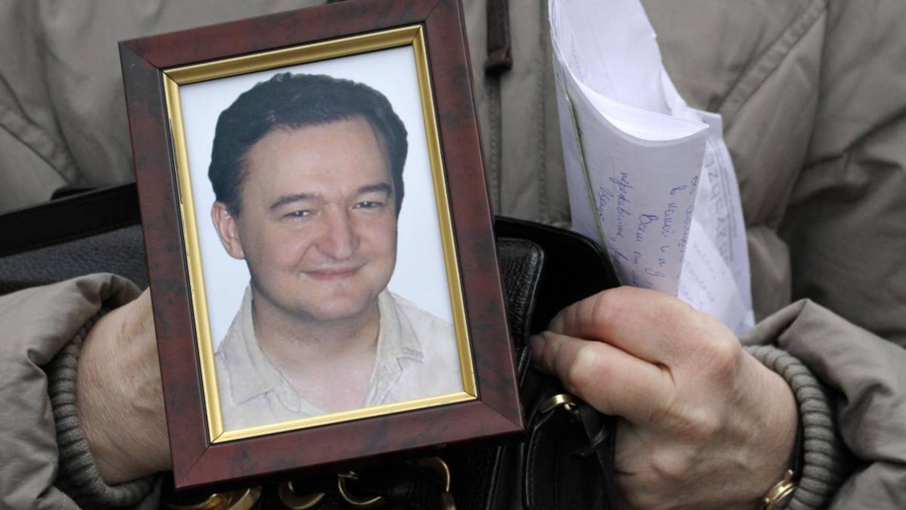 Nataliya Magnitskaya, mother of lawyer Sergei Magnitsky who died in jail two weeks ago, holds a portrait of him and letters he sent to her from jail, as she speaks in central Moscow, Russia, Nov. 30, 2009 (AP)