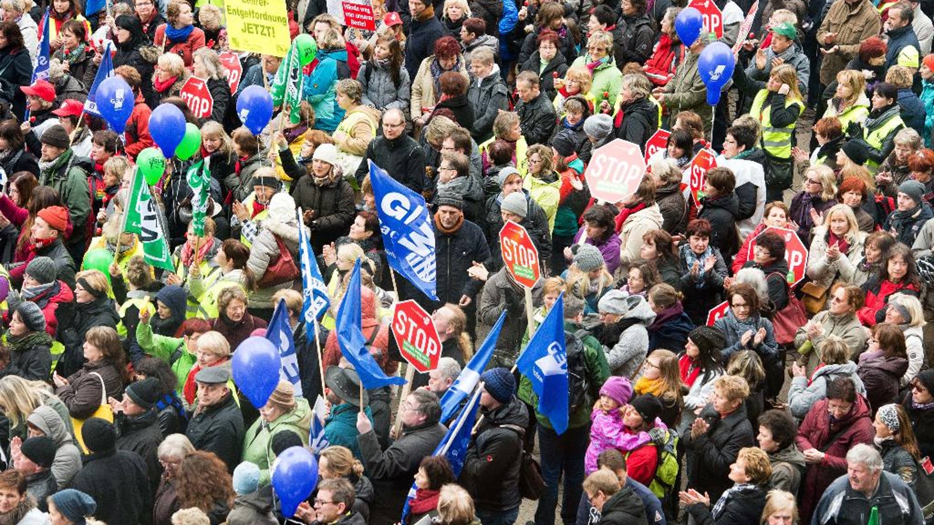 Teacher join al rally in a bid to receive higher wages and preserve pension benefits in Leipzig, Germany, Wednesday, March 11, 2015. The ver.di union said besides teachers other public employees including police and firefighters walked off the job in multiple states in Germany. (AP Photo/dpa, Peter Endig)