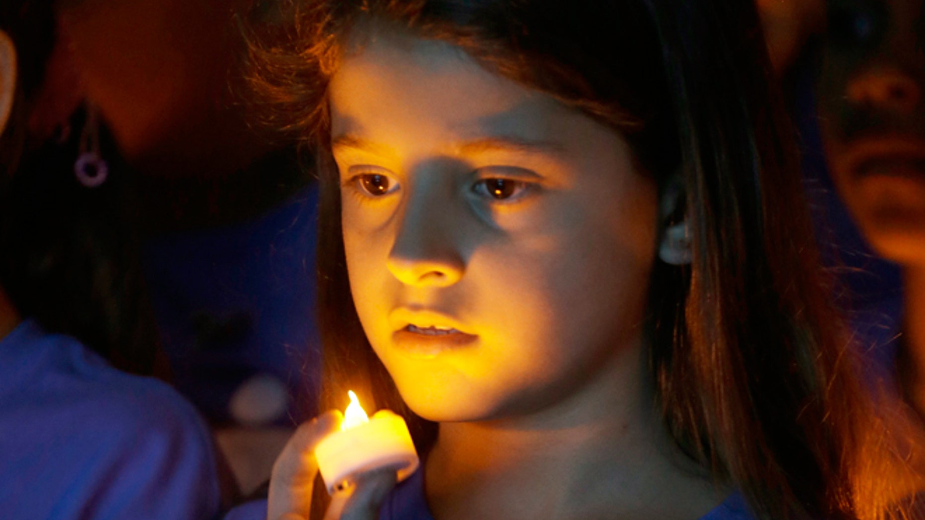 FILE -- April 23, 2014: Melanie Mamondes, 8, participates in a candlelight vigil commemorating National Child Abuse Prevention Month at Jose Marti Park in Miami. Amigos For Kids, a nonprofit organization dedicated to preventing child abuse and neglect, held the event attended by about 200 kids and their families.