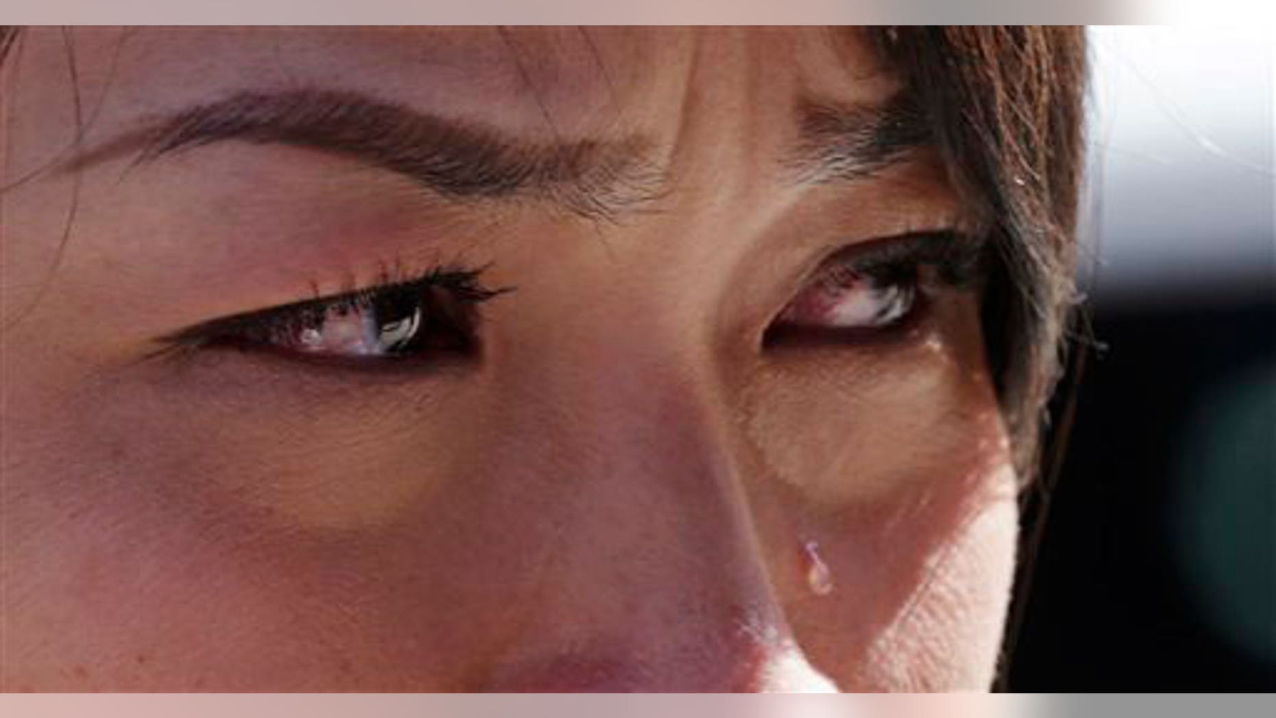 Wednesday, April 17, 2013: Boston Marathon runner Vu Trang, of San Francisco, cries at a makeshift memorial on Boylston Street near the finish line of Monday's Boston Marathon explosions, which killed at least three and injured more than 140.