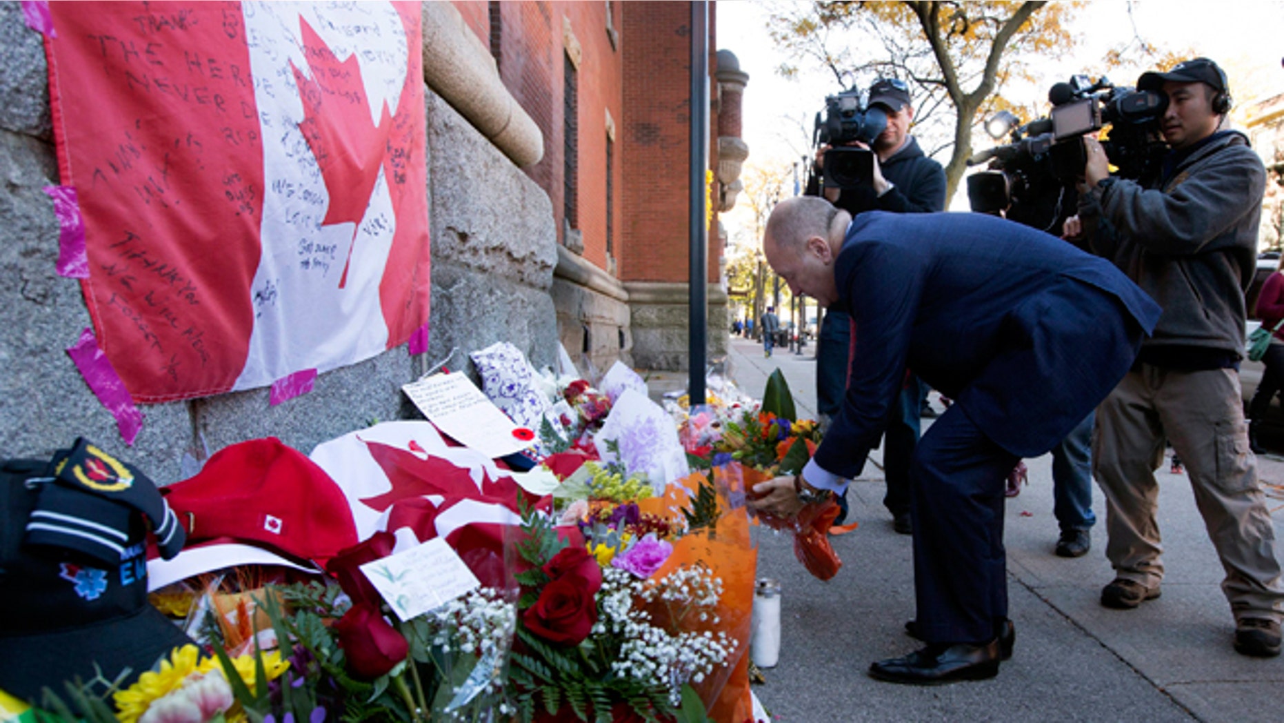 Oct. 23, 2014: Bruce Heyman, the American Ambassador to Canada, places flowers at a makeshift memorial to Cpl. Nathan Cirillo outside of The Lieutenant-Colonel John Weir Foote Armoury in Hamilton, Ontario.